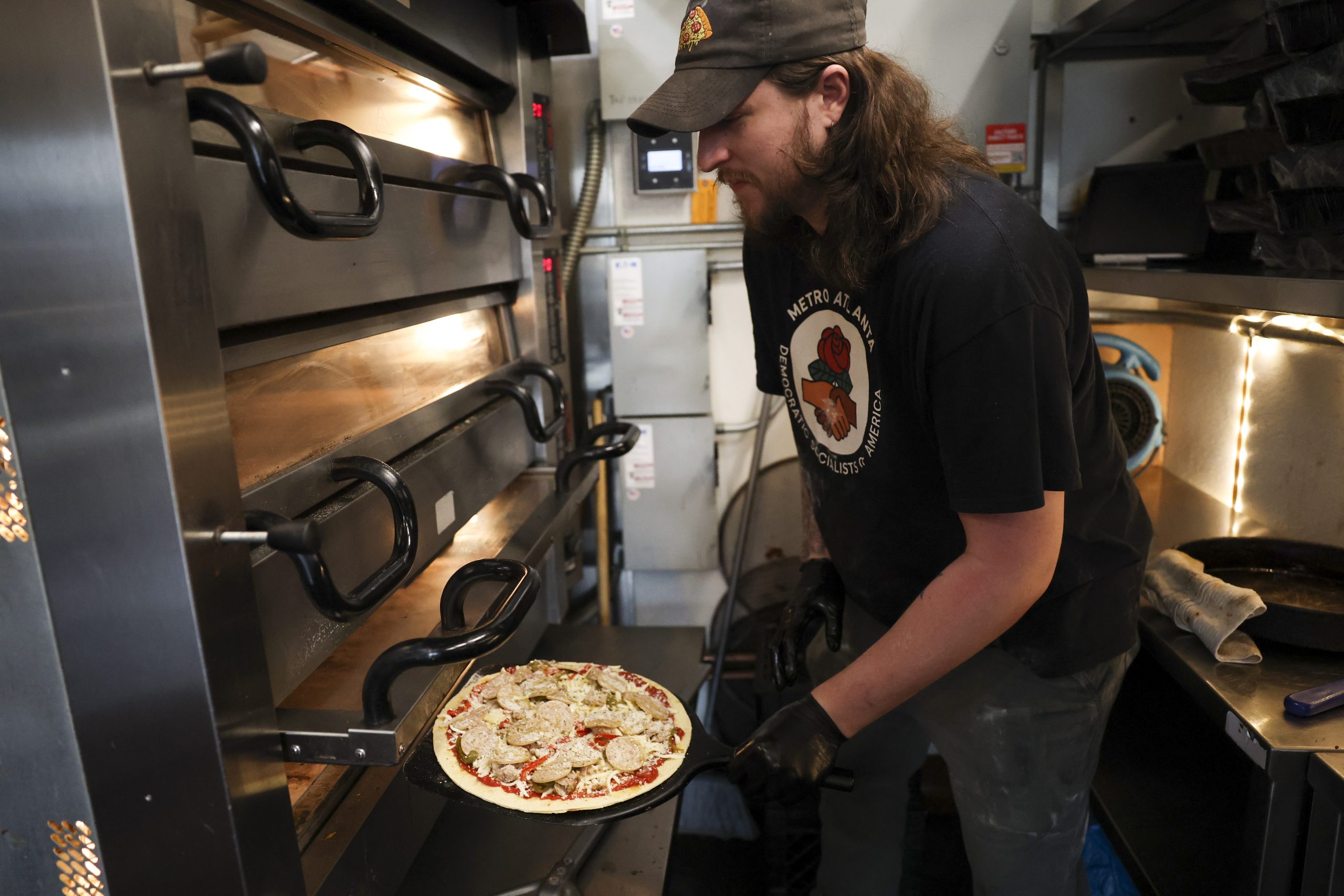 Michael Sundstrom puts a pizza in the oven at Professor...