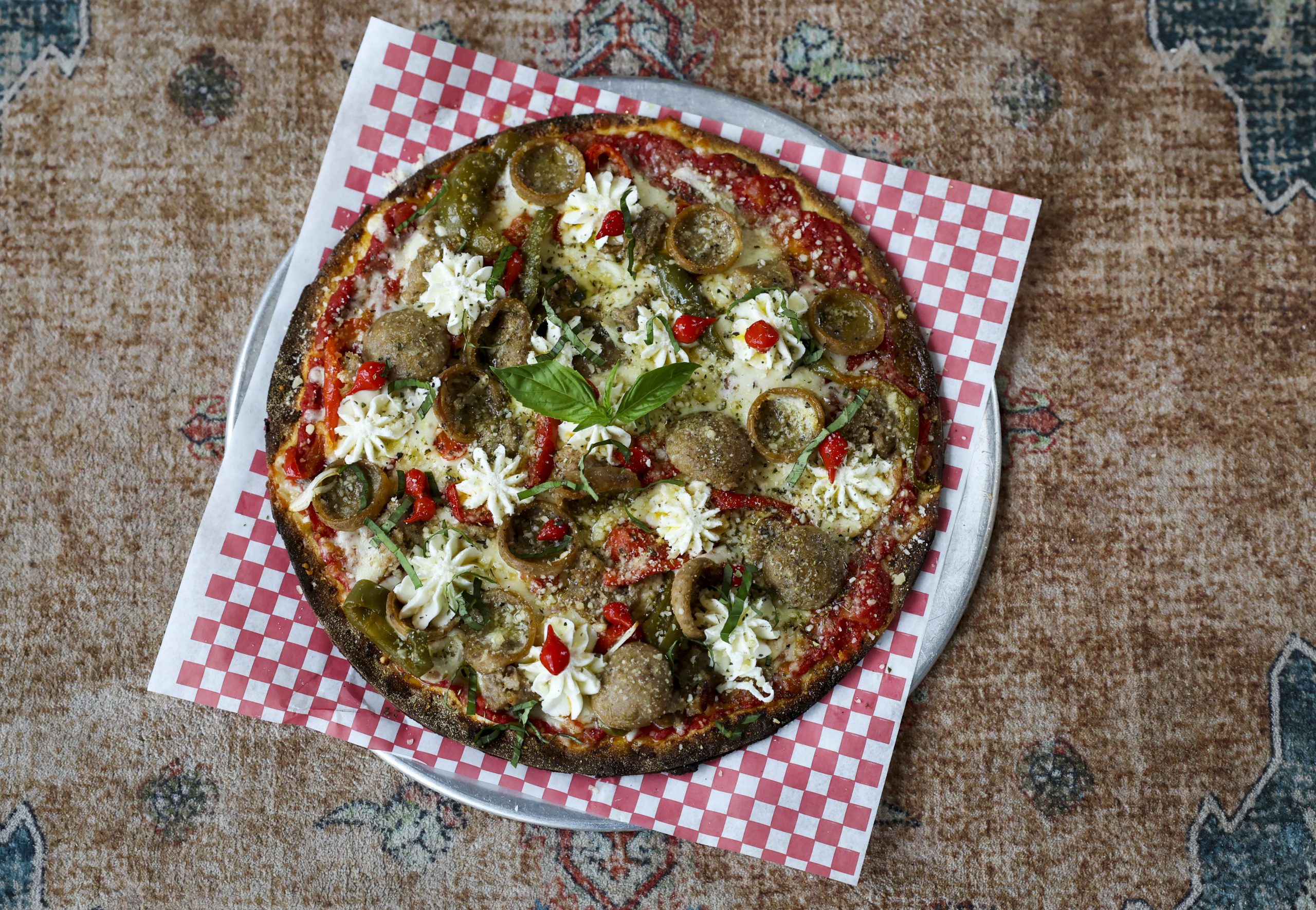 The deluxe sausage and pepper pizza with whipped ricotta on...