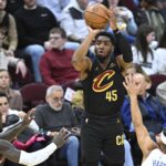 Cleveland Cavaliers guard Donovan Mitchell shoots ball over New York Knicks defenders