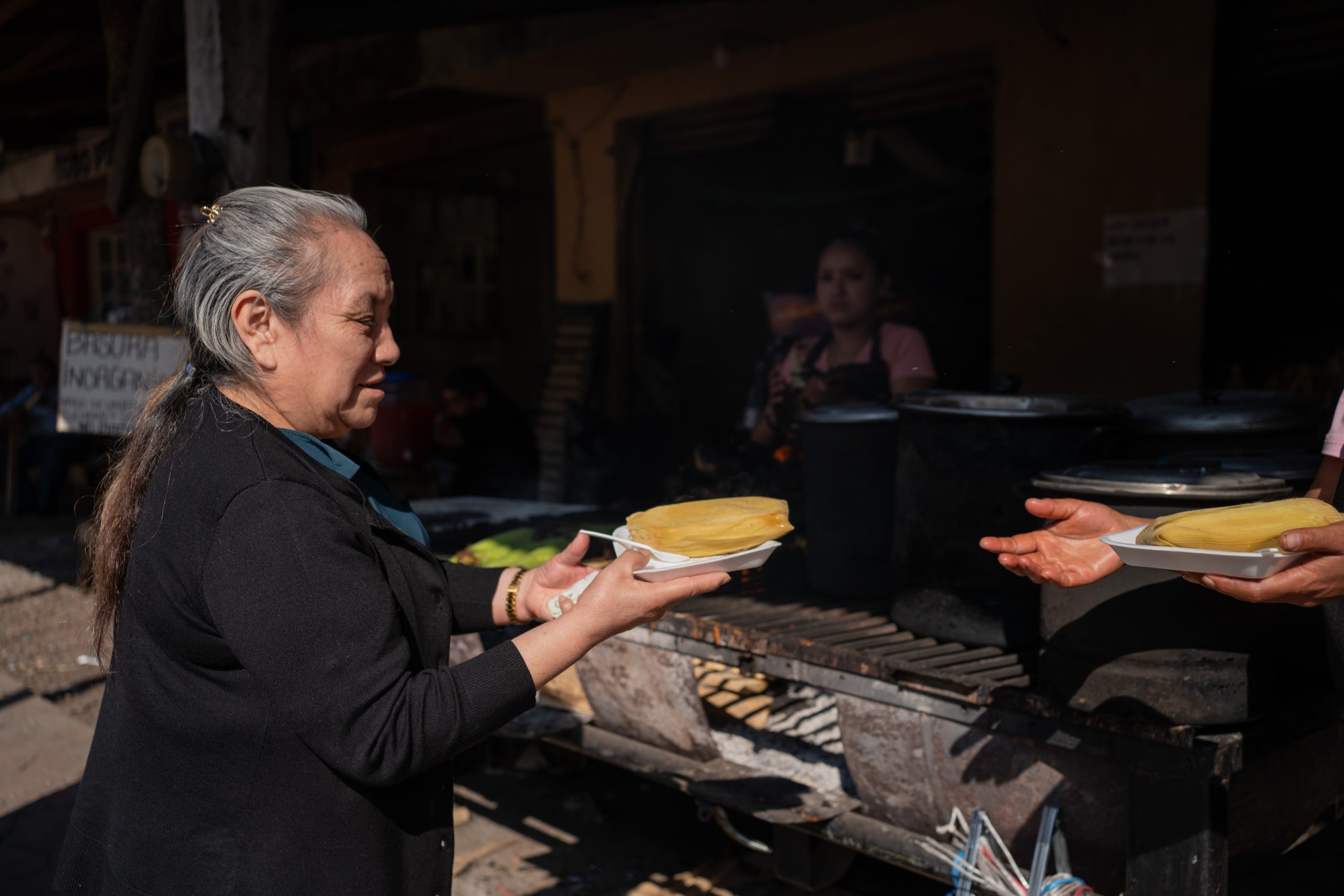 Claudia Perez buys wood-fired tamales to eat in Coacuatzintla, Veracruz,...