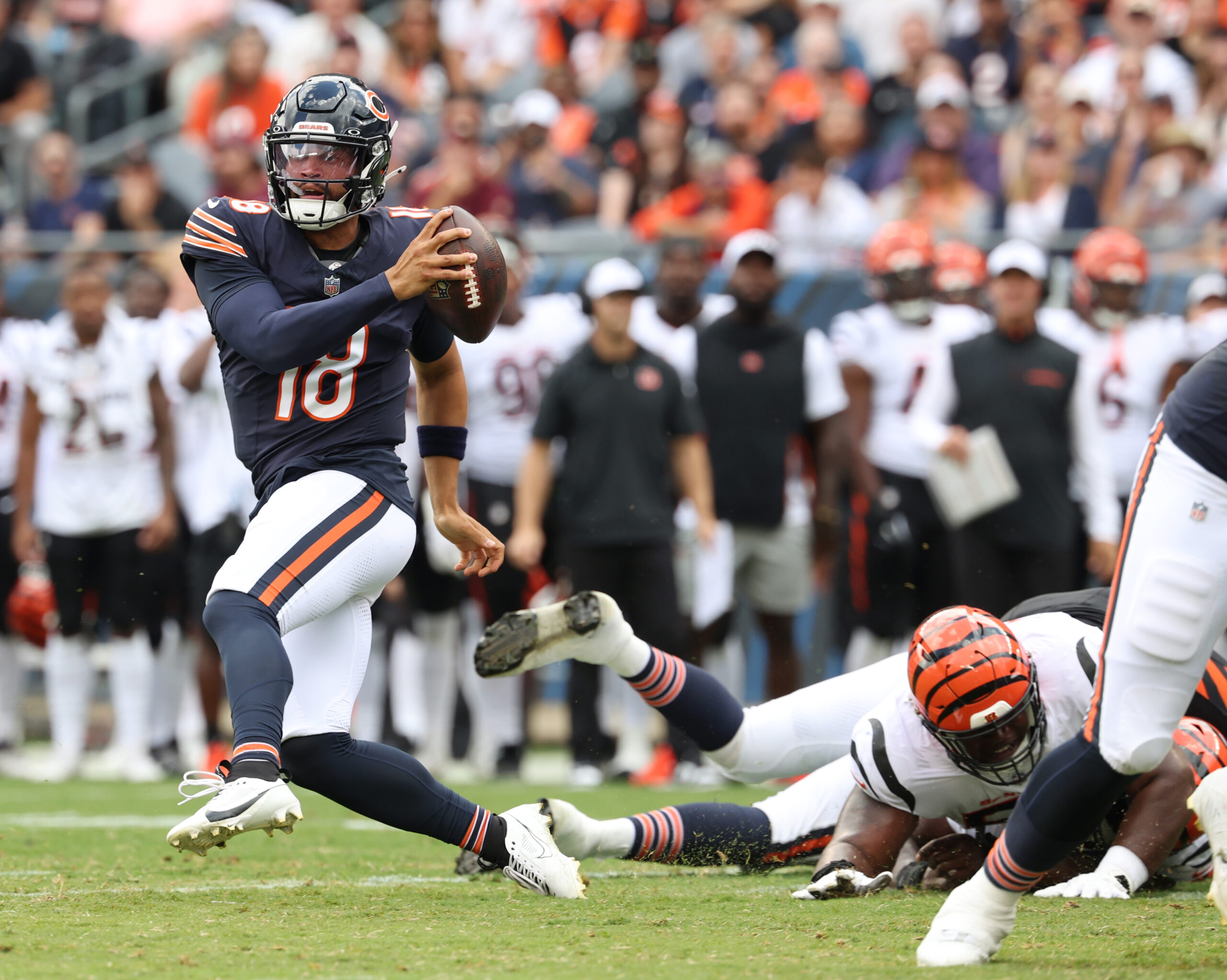 Bears quarterback Caleb Williams escapes Bengals defenders before rushing for...