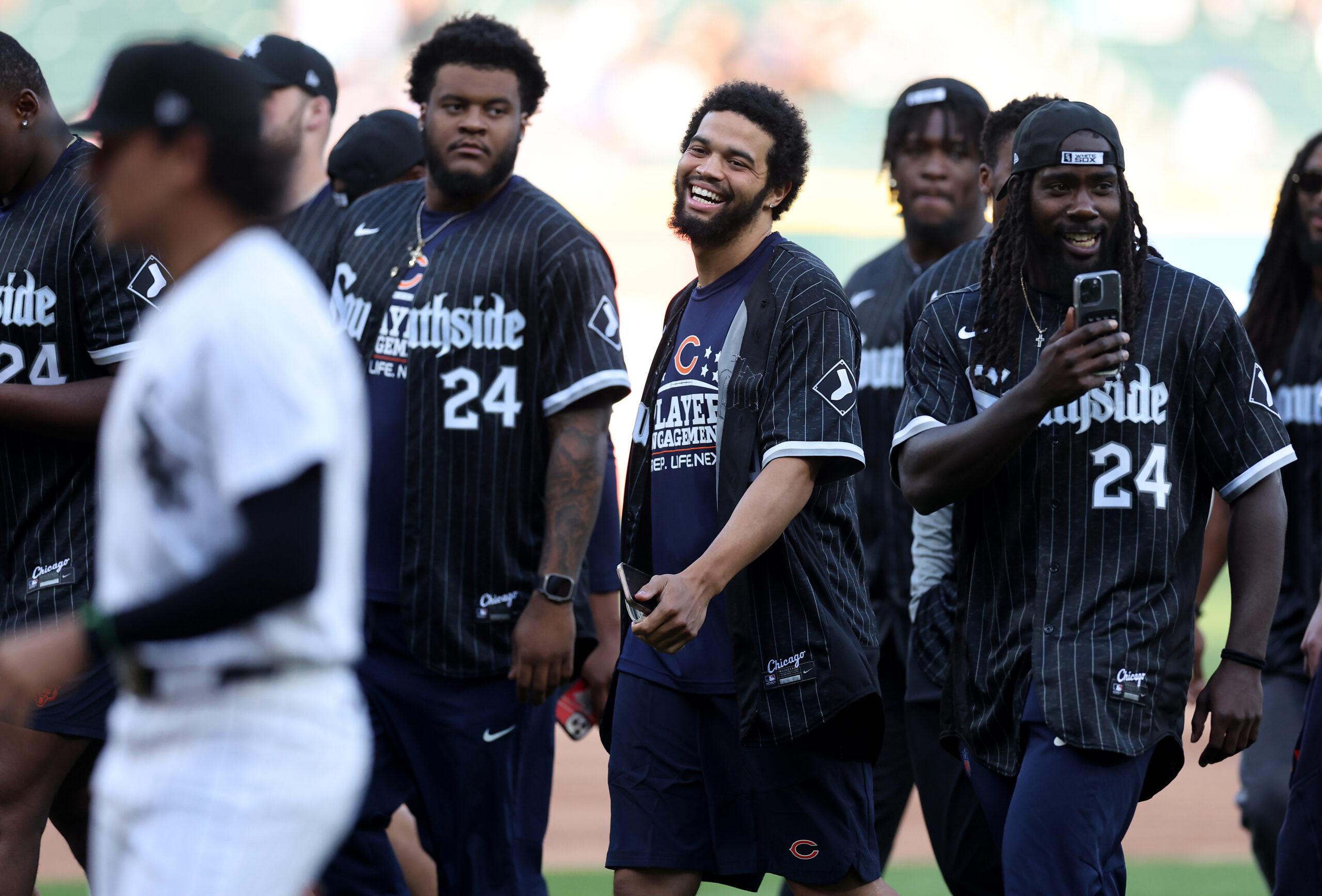 Chicago Bears quarterback Caleb Williams (center) has a laugh as...
