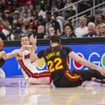 Miami Heat forward Duncan Robinson (55) passes from the floor between Atlanta Hawks guard Keaton Wallace (2) and forward Larry Nance Jr. (22)