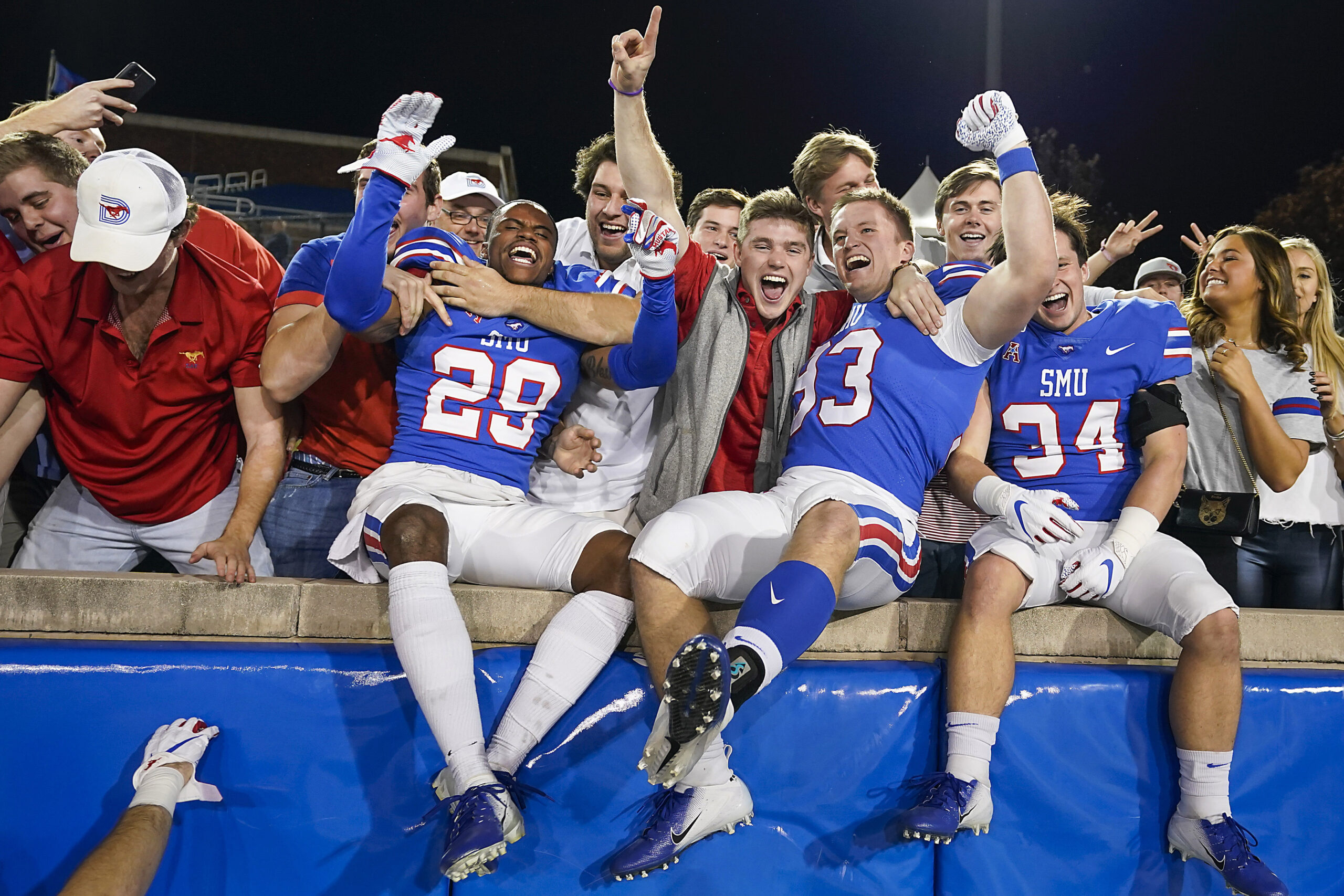 SMU cornerback Justin Guy-Robinson (29), kicker Kevin Miles (93) and safety Brice Madison (34) celebrate with fans after a 37-20 victory over Tulane on Nov. 30, 2019, in Dallas. SMU cornerback Justin Guy-Robinson (29), kicker Kevin Miles (93) and safety Brice Madison (34) celebrate with fans after a 37-20 victory over Tulane on Nov. 30, 2019, in Dallas.