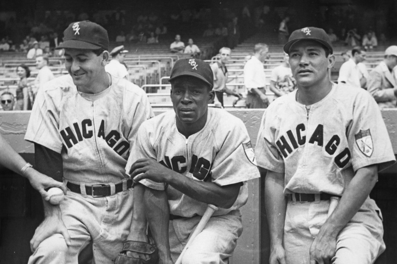L-R, Luis Alomá (1923 - 1997), Pitcher, Orestes “Minnie” Miñoso (1923 - 2015), Left Fielder and Chico Carrasquel (1926 - 2005), Shortstop for the Chicago White Sox pose in the team dugout before the Major League Baseball American League game against the New York Yankees on 19th June 1951 at Yankee Stadium in the Bronx, New York, New York, United States.