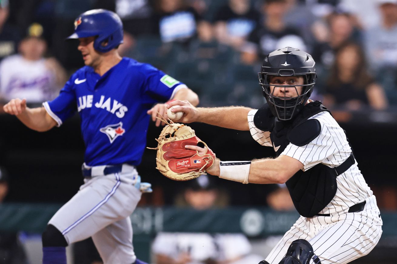 Kyle Teel #8 of the Chicago White Sox fields a sacrifice bunt as Ernie Clement #22 of the Toronto Blue Jays scores in the sixth inning at Rate Field on July 7, 2025 in Chicago, Illinois.