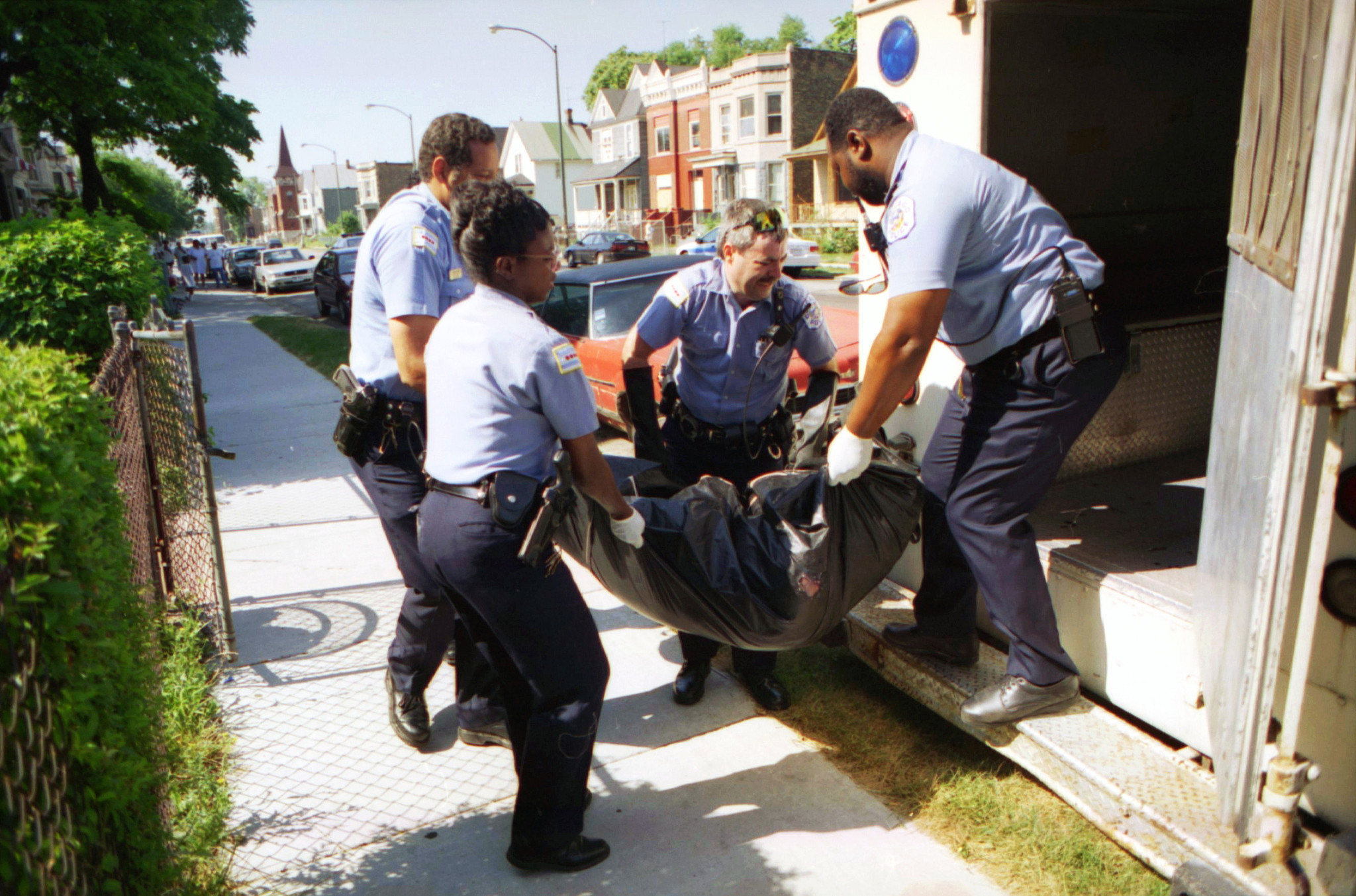 Chicago police officers, including Charley Henson, second from right, carry the body of Marie Brown, who died of heat-related causes from her apartment on July 17, 1995. (Phil Greer/Chicago Tribune)