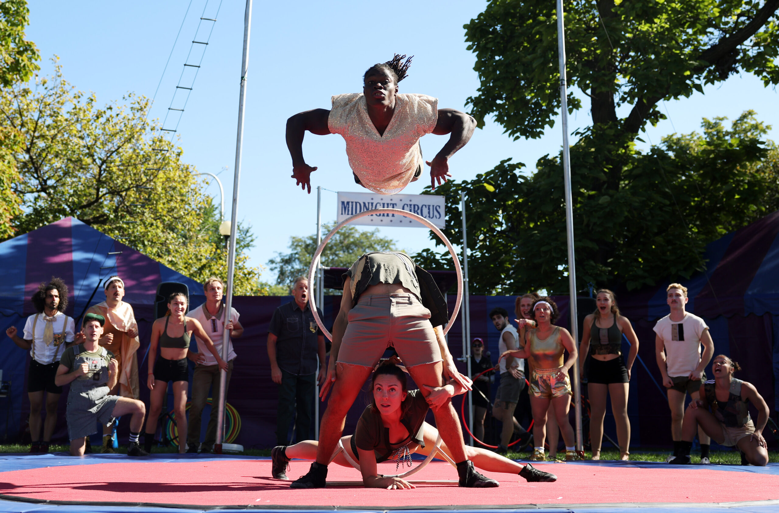 Midnight Circus member Alseny Sylla leaps above Dominic Cruz, center,...