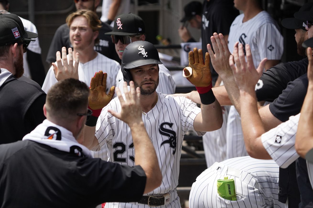 Chicago White Sox outfielder Andrew Benintendi (23) is greeted in the dugout after hitting a home run against the Chicago Cubs during the first inning at Rate Field.