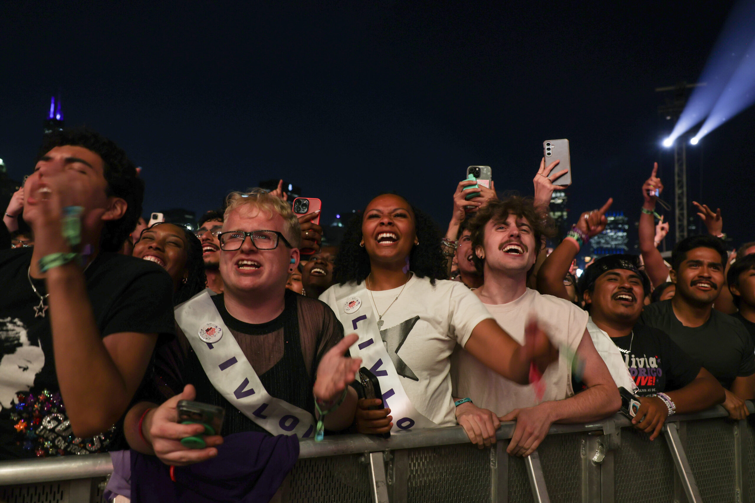 Festival attendees excitedly watch Olivia Rodrigo perform at Lollapalooza, Aug....
