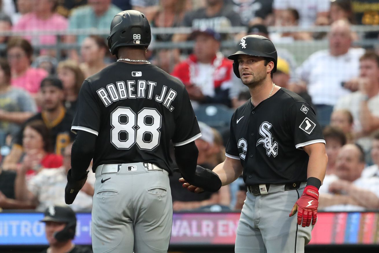 Chicago White Sox center fielder Luis Robert Jr. (88) and designated hitter Andrew Benintendi (right) celebrate after both players scored runs against the Pittsburgh Pirates during the sixth inning at PNC Park.
