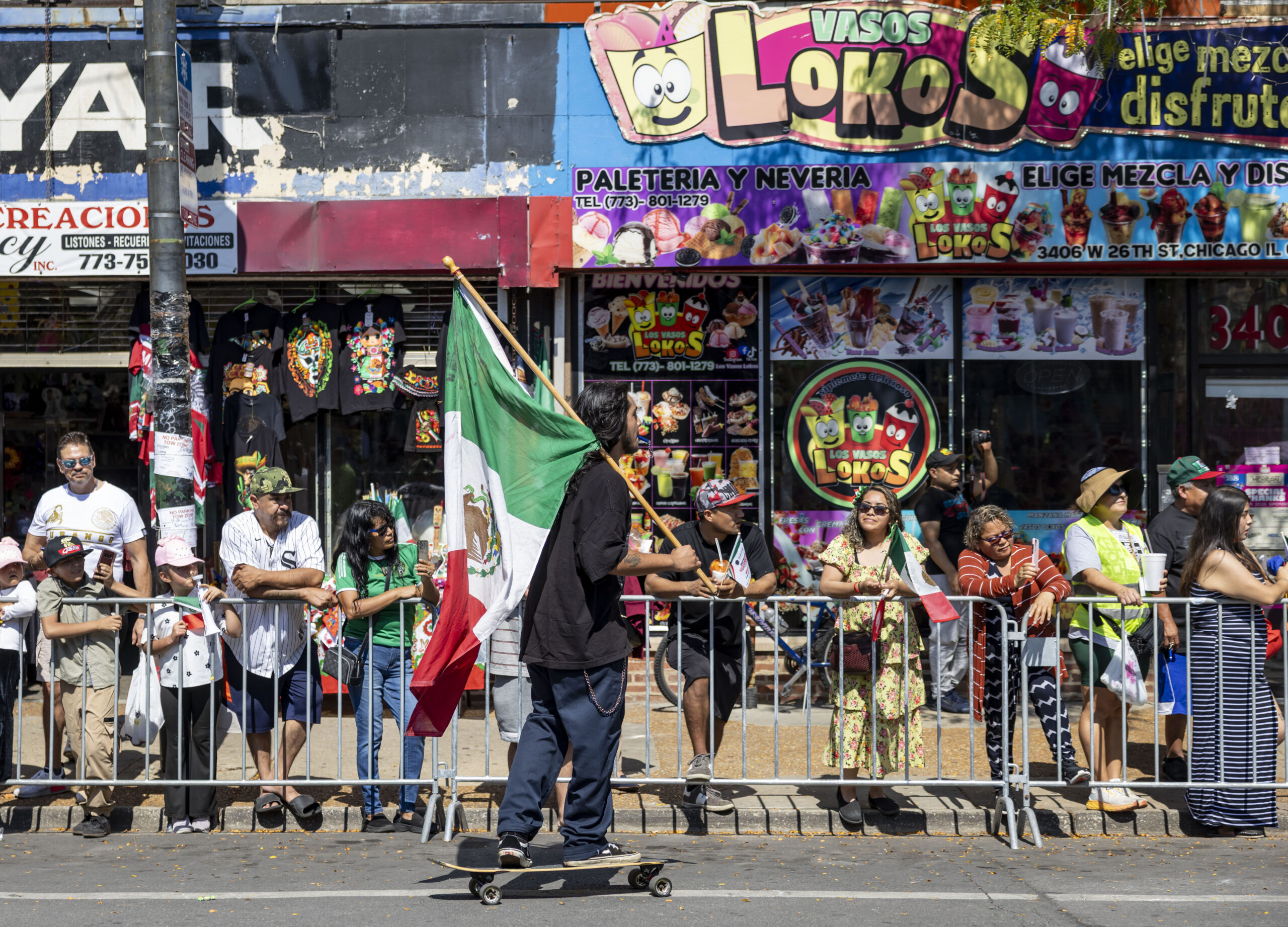 A skateboarder carries a flag in the annual 26th Street...