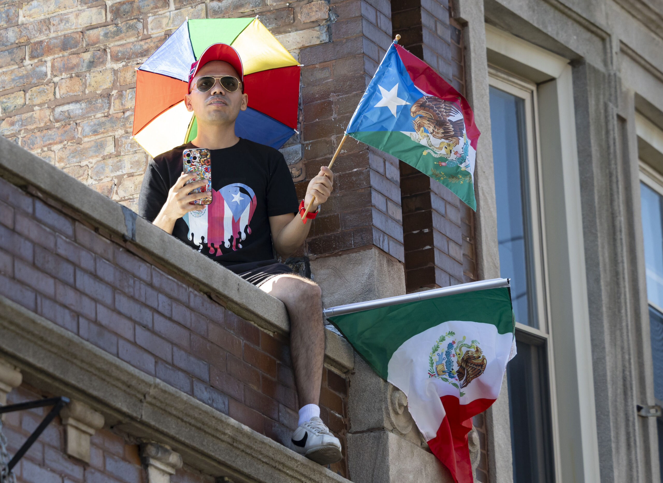 A man watches from a rooftop during the annual 26th...
