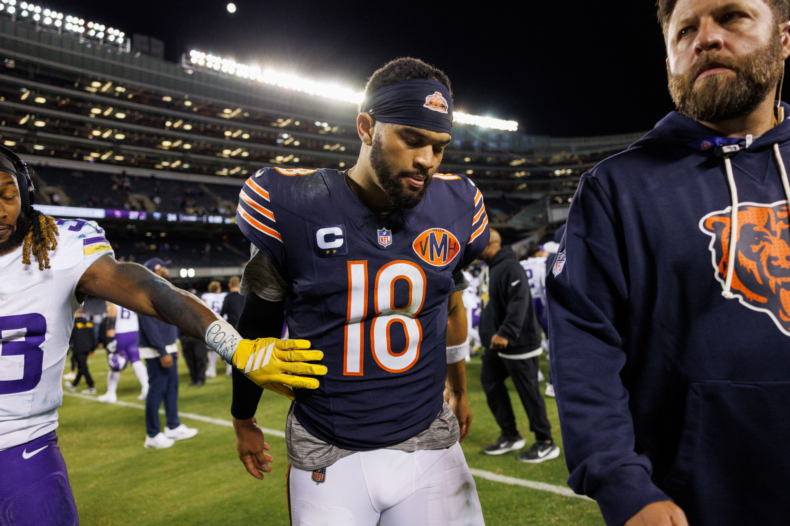 Bears quarterback Caleb Williams walks off the field after the...