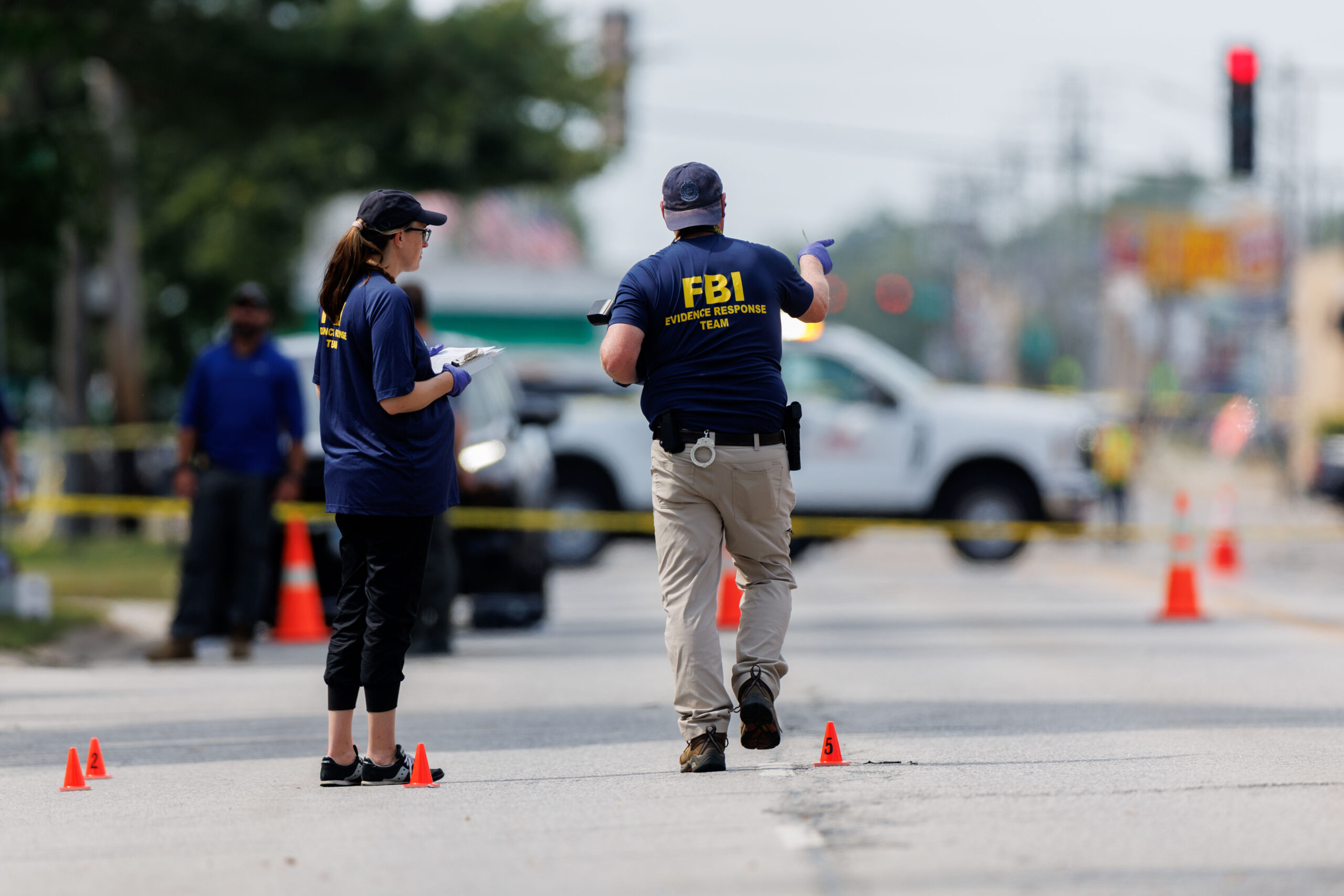 Members of the FBI and other law enforcement officers investigate...