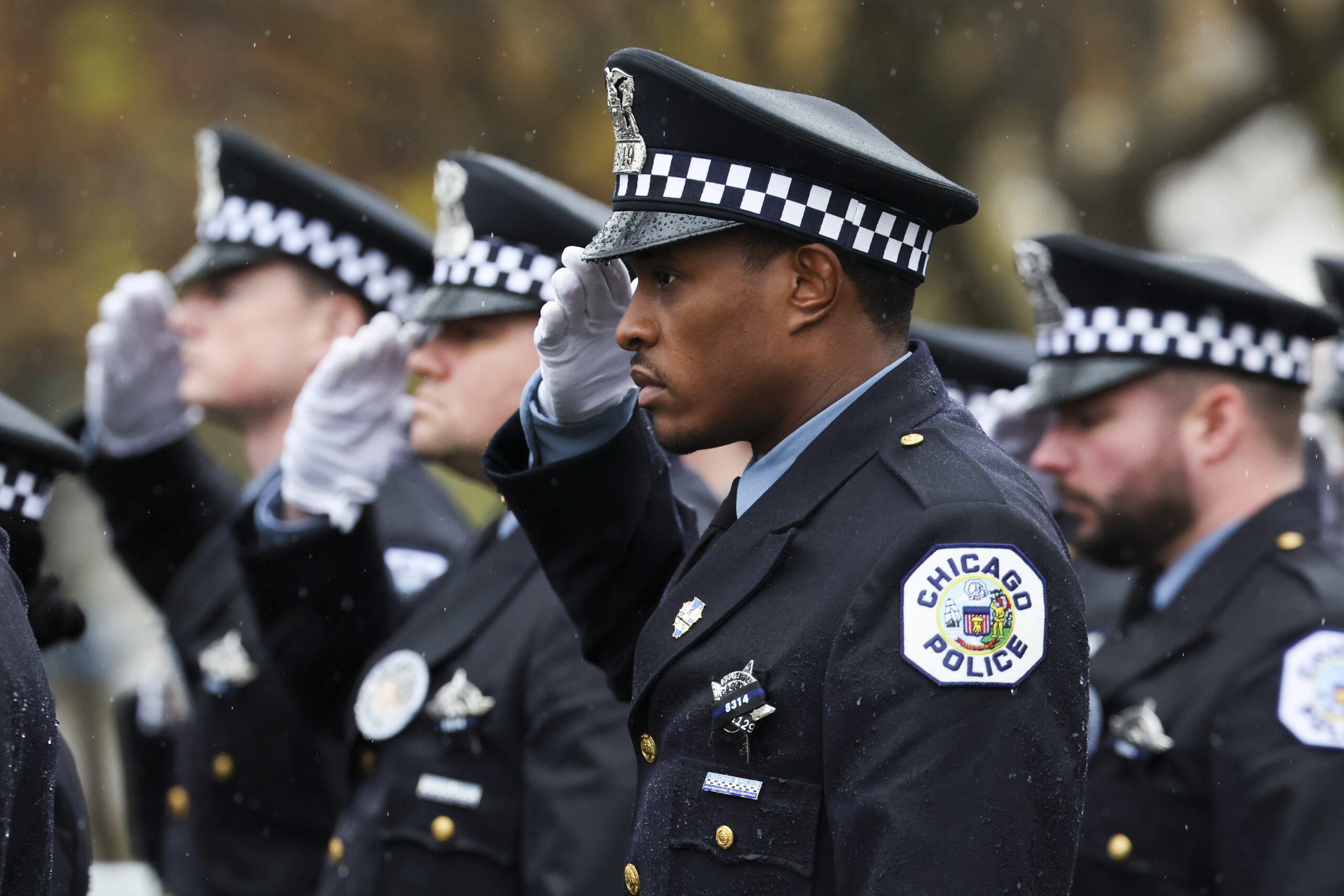 Chicago police officers salute at the funeral for slain Chicago...