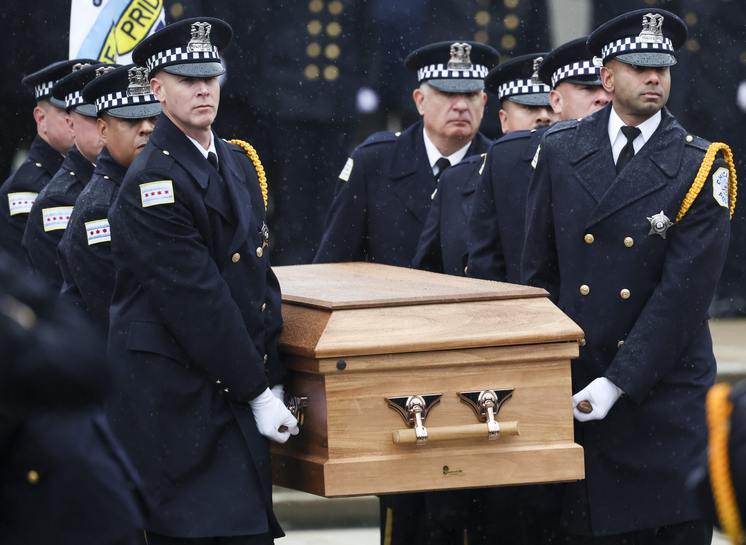 Pallbearers carry the coffin to the hearse during the funeral...