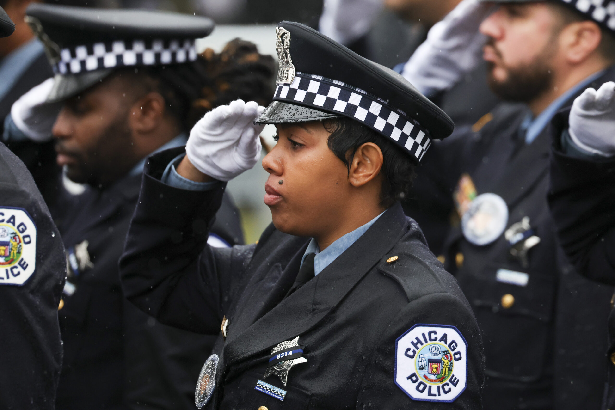 Chicago police officers salute at the funeral for slain Chicago...