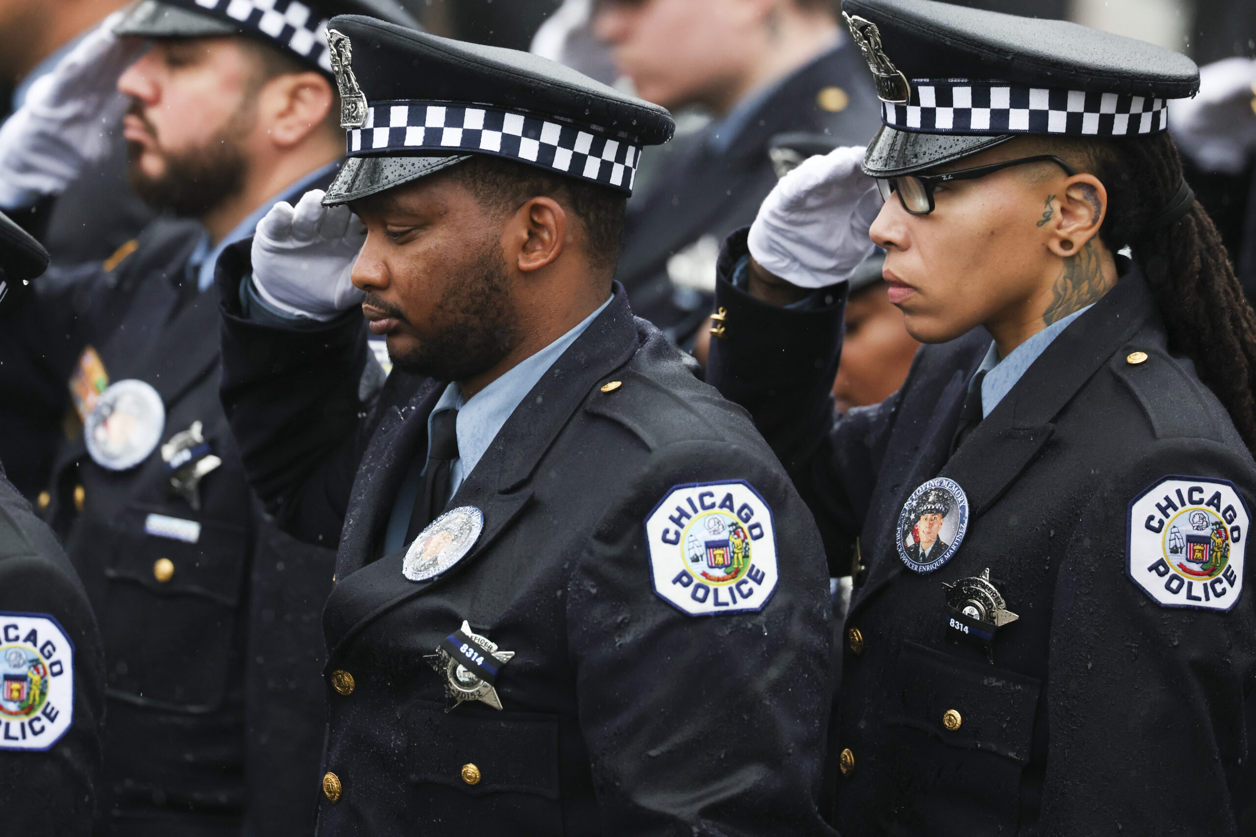 Chicago police officers salute at the funeral for slain Chicago...