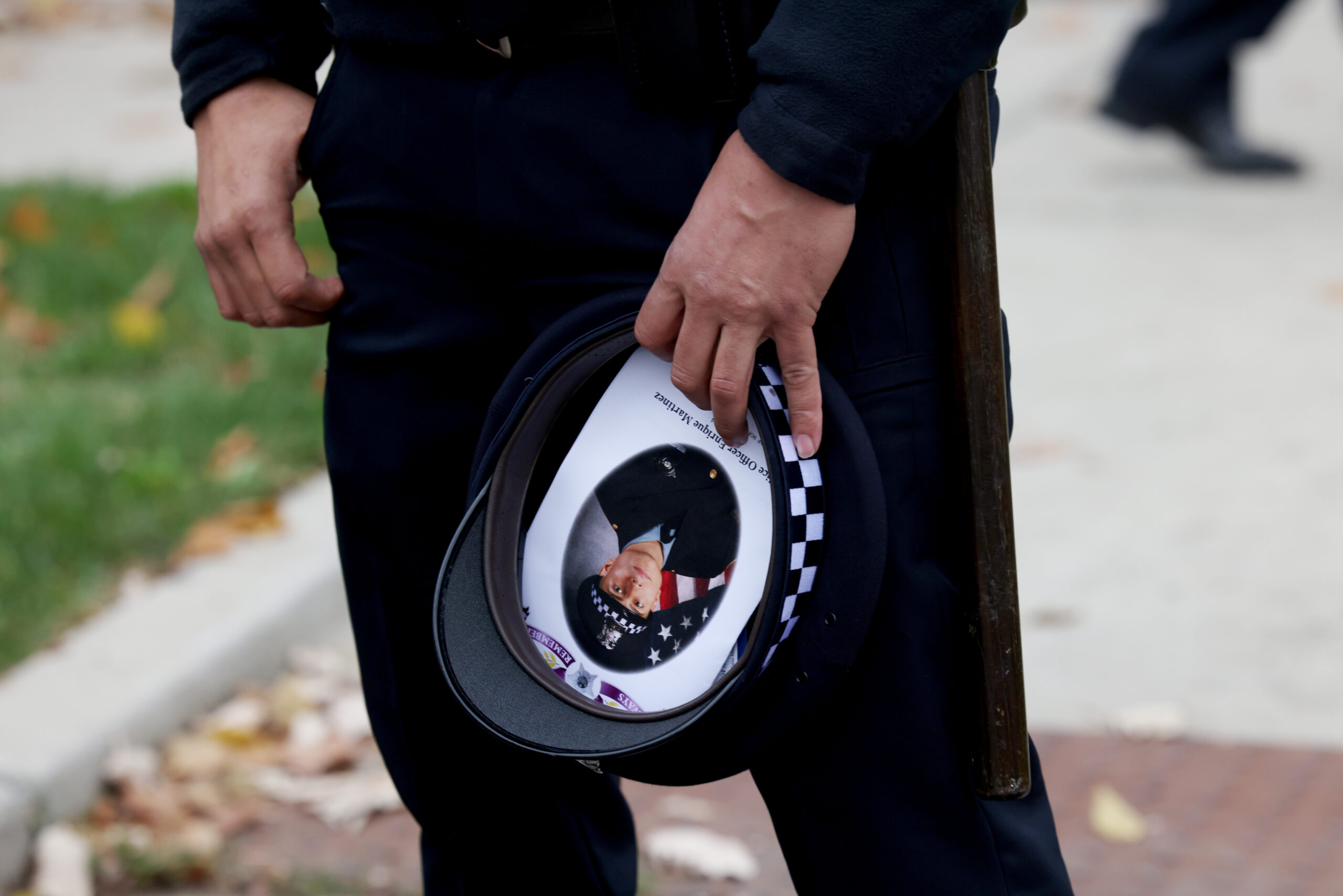 A police officer carries a hat with a photo of...