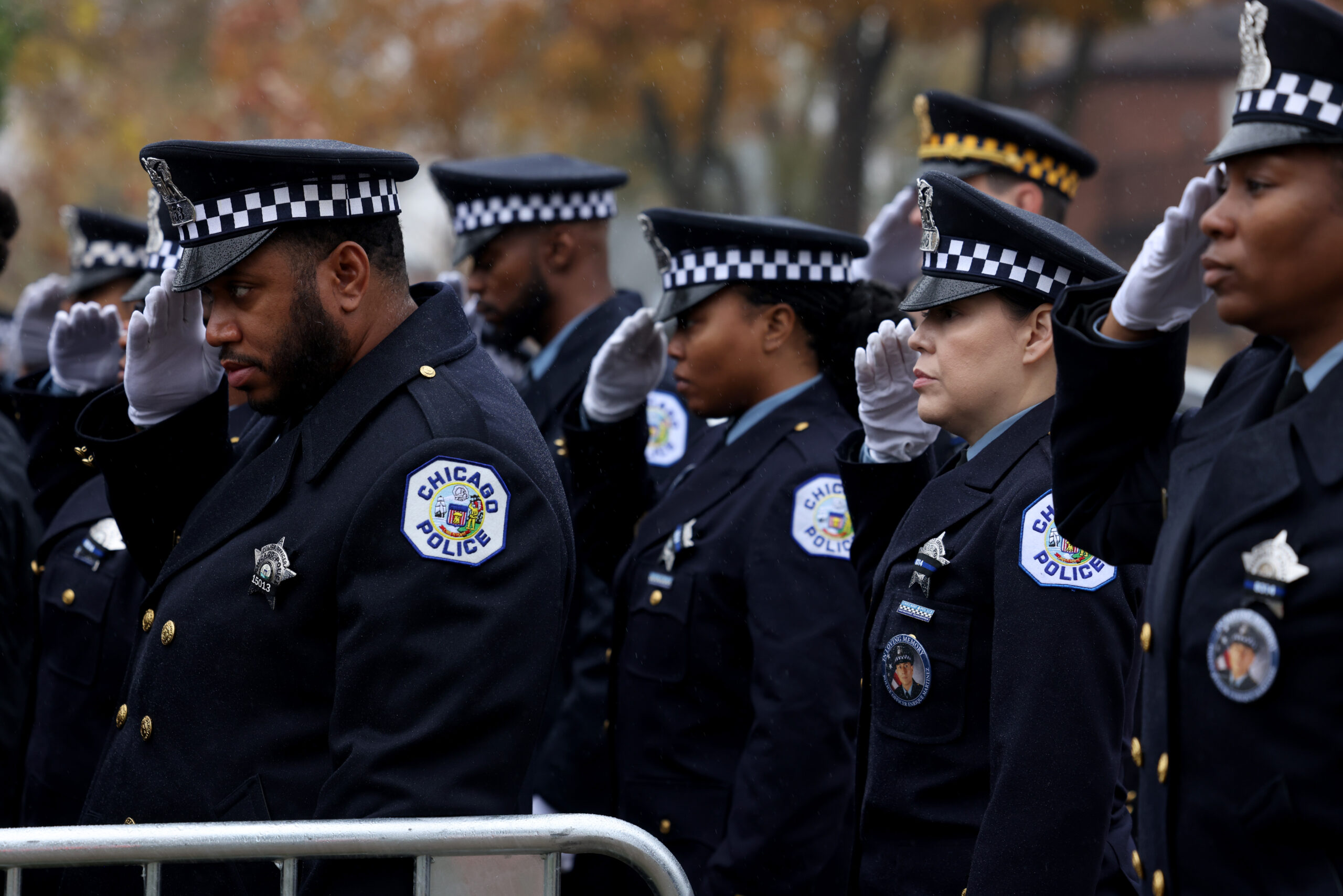 Officers salute as the hearse arrives for the funeral for...