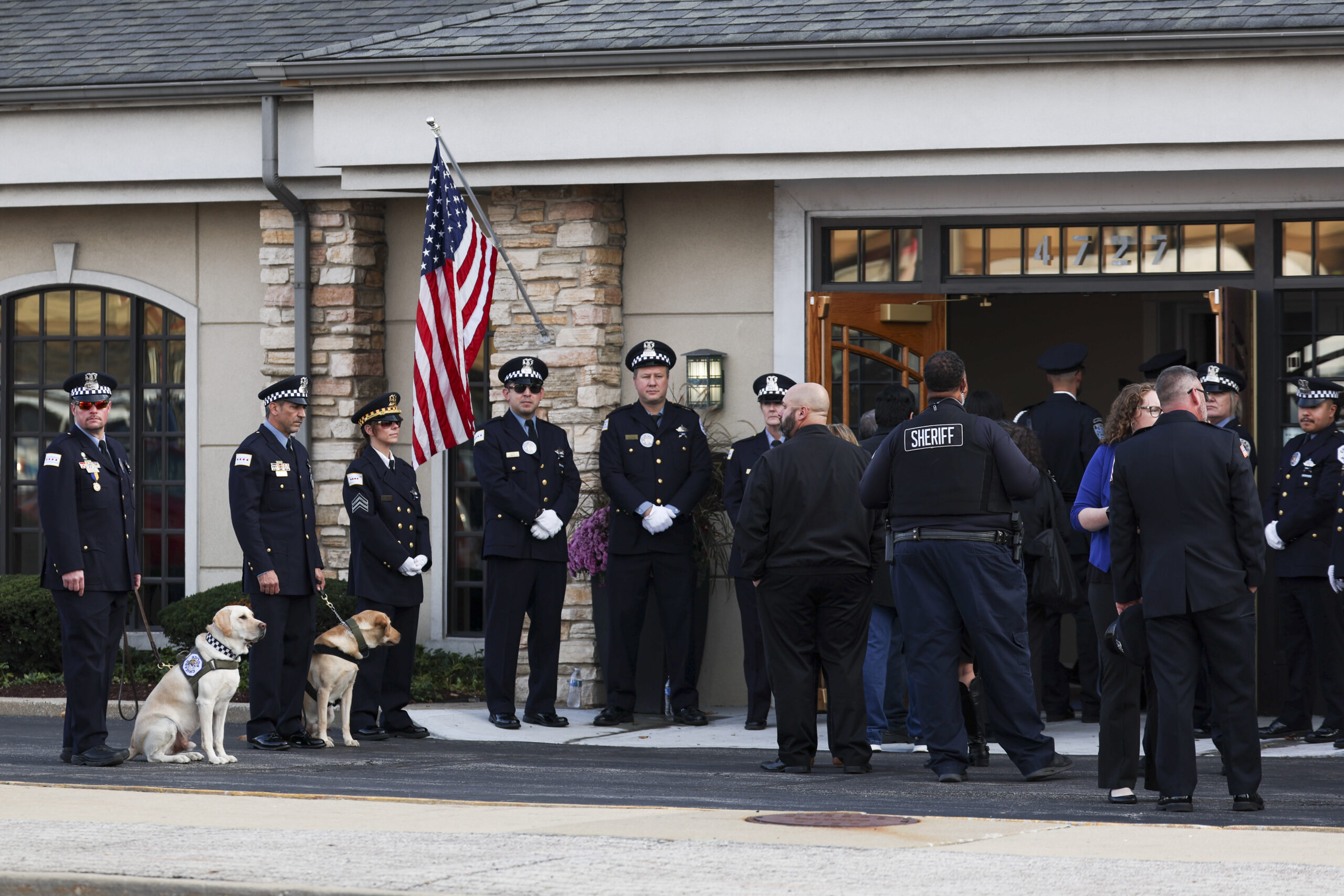 Police officers and mourners wait outside of Blake-Lamb Funeral Home...