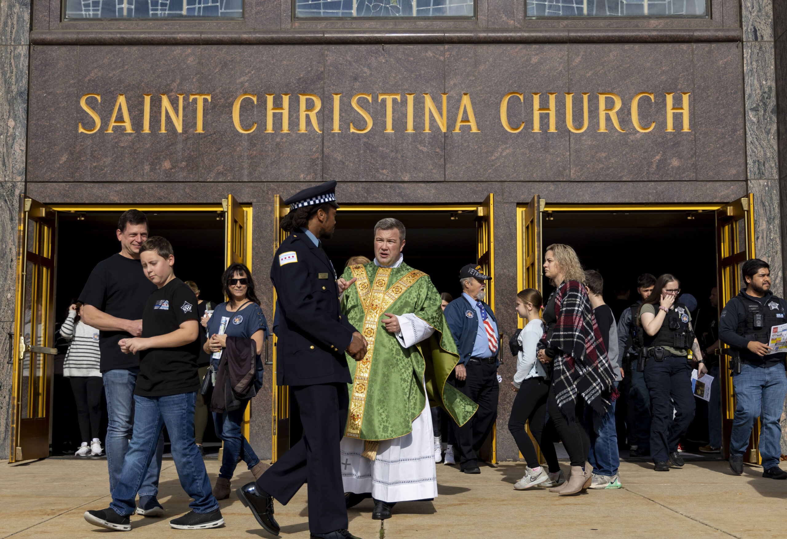 The Rev. Ryan Brady greets people after a Mass dedicated...