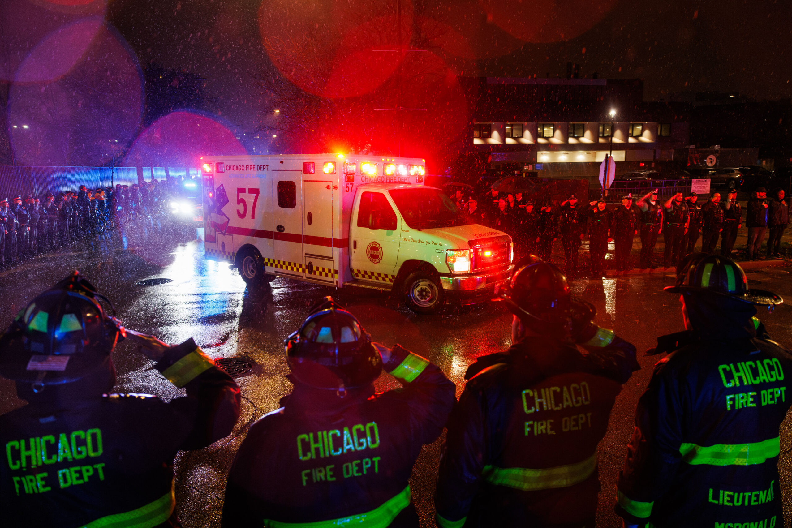 Members of the Chicago fire and police departments salute in...