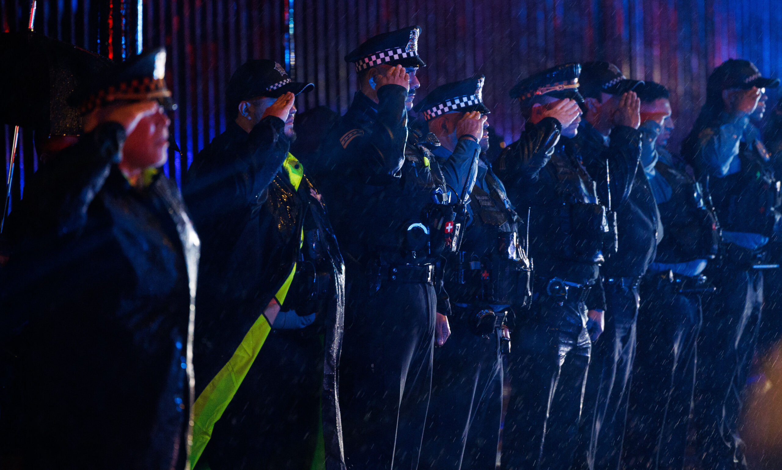 Members of the Chicago Police Department salute in the rain...
