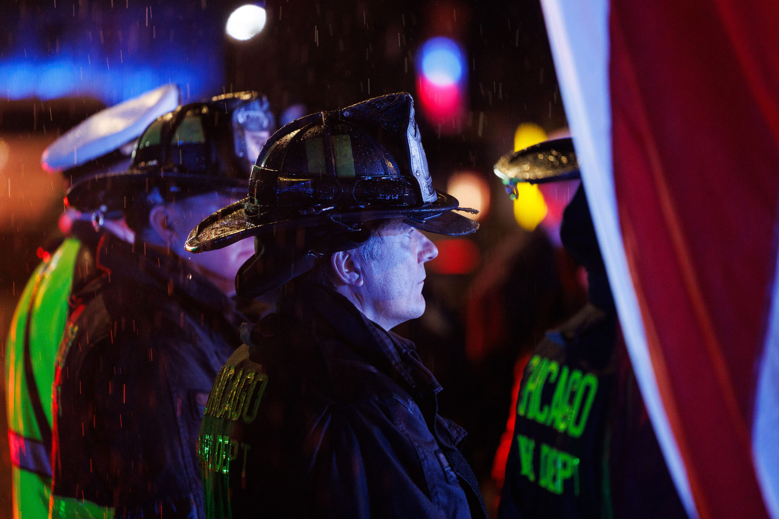 Members of the Chicago Fire Department wait in the rain...