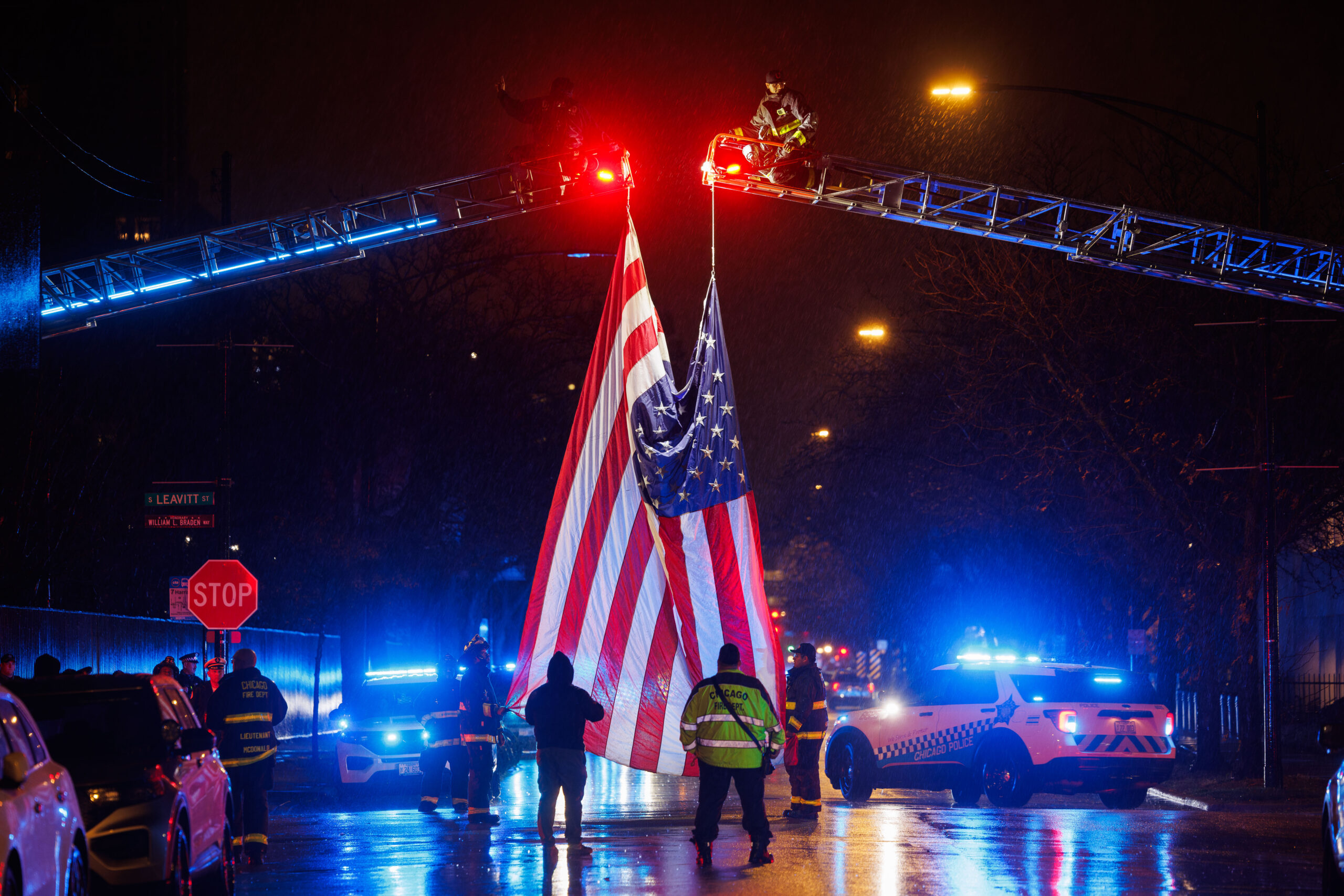 Chicago firefighters hang a flag outside the Cook County medical...