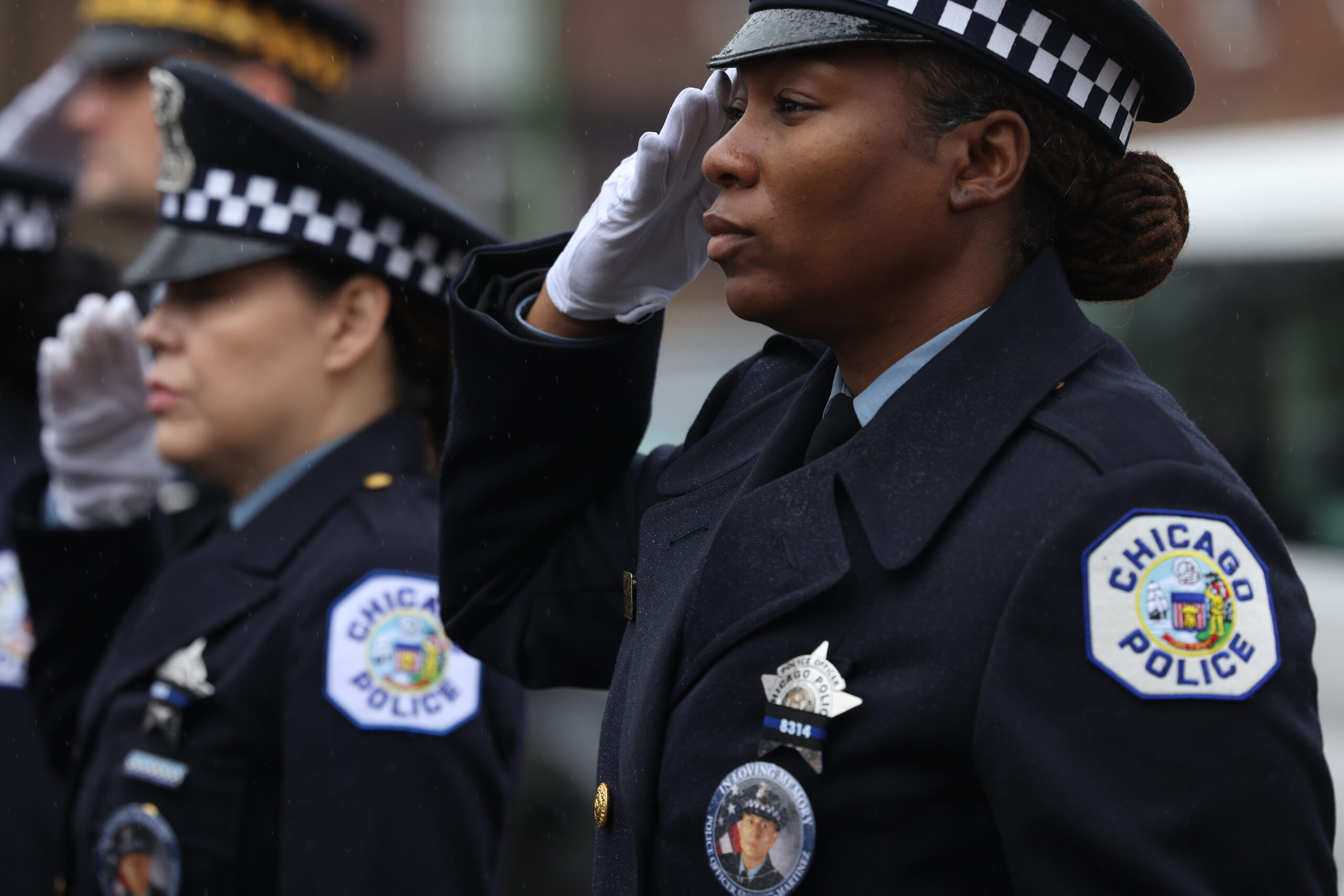 Police officers salute at the start of funeral services for...