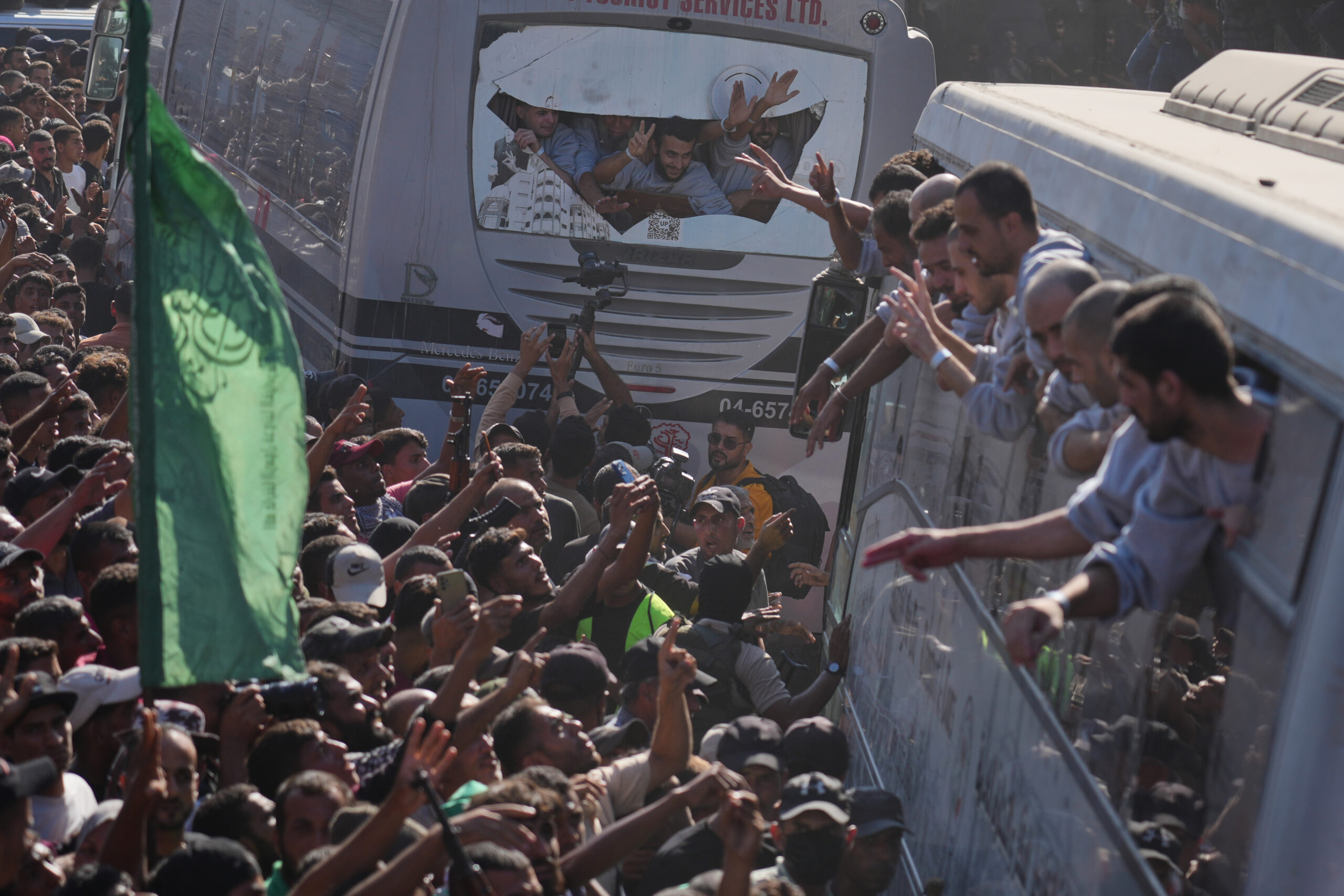 People gather to greet freed Palestinian prisoners arriving on buses...
