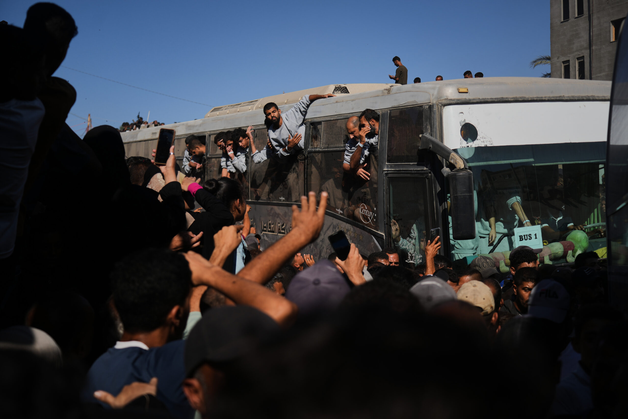 People gather to greet freed Palestinian prisoners arriving on buses...