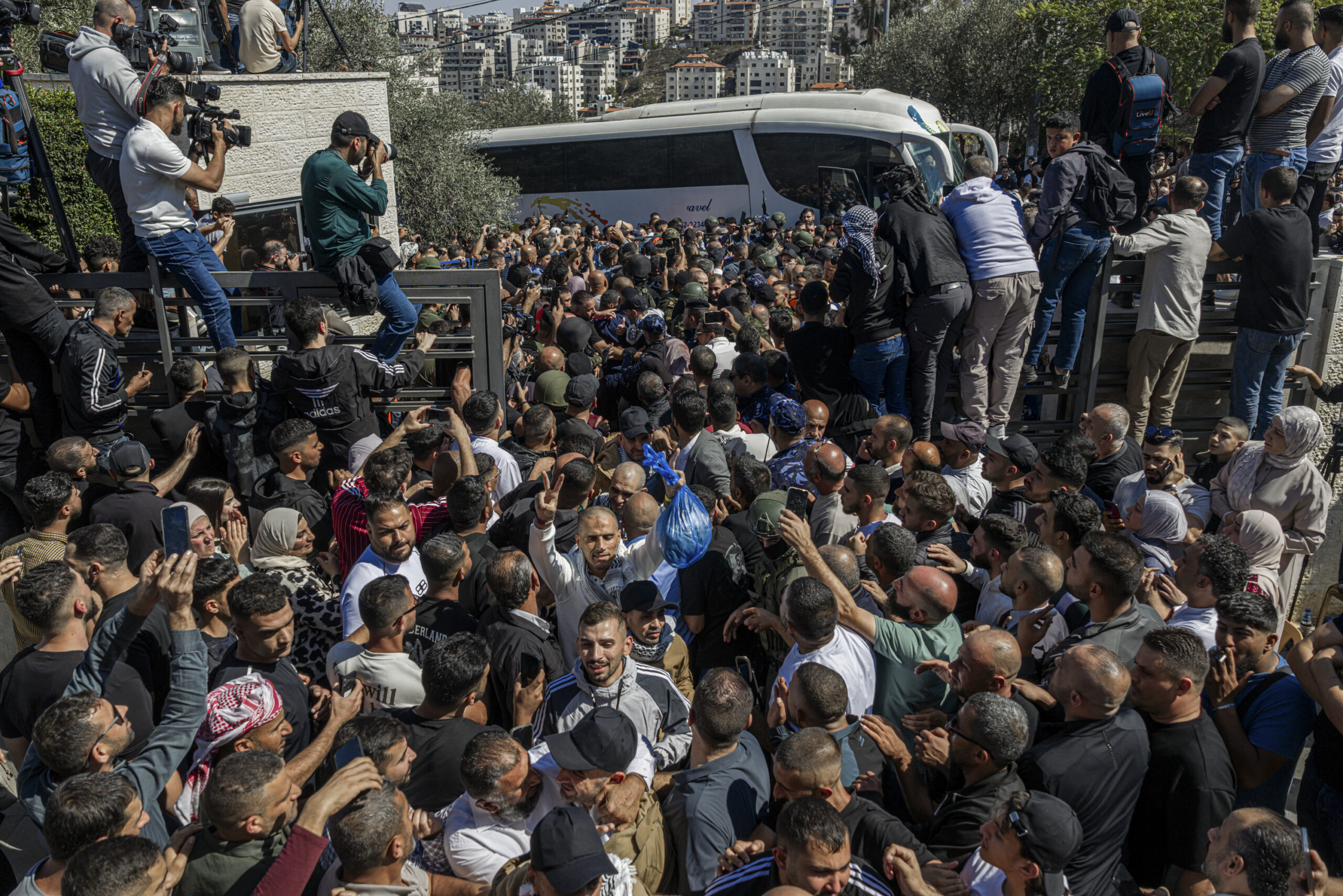 Palestinians celebrate as buses of released Palestinian prisoners arrive after...