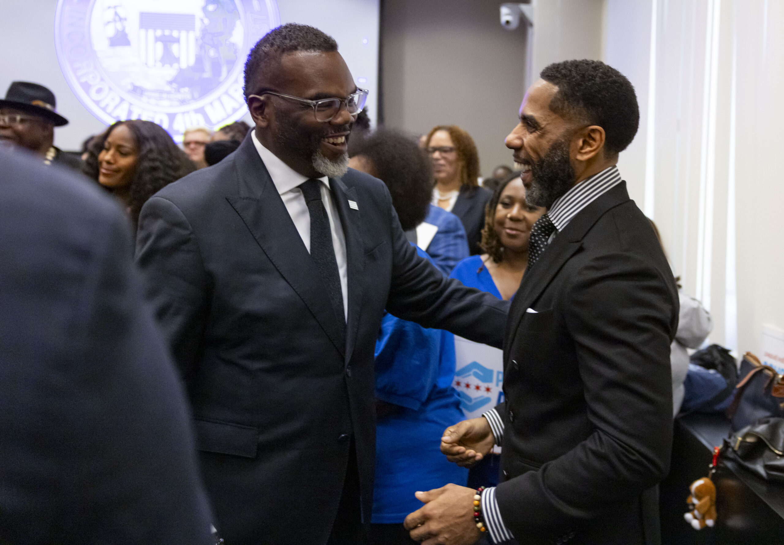 Mayor Brandon Johnson, left, greets Sean Harden, president of the...