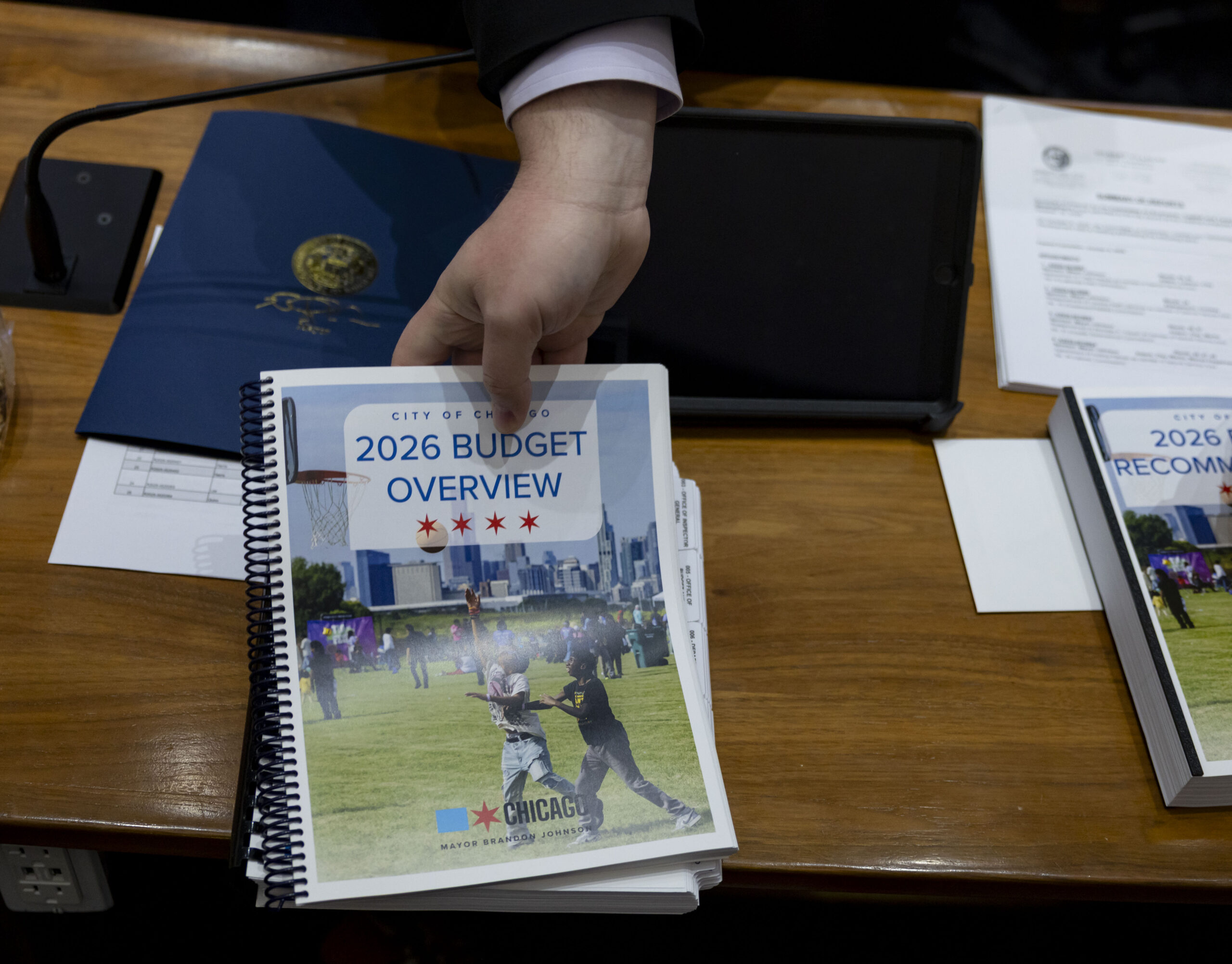 Copies of the budget overview are distributed to City Council members Oct. 16, 2025 after Mayor Brandon Johnson delivered his budget address at Chicago City Hall. (Brian Cassella/Chicago Tribune)