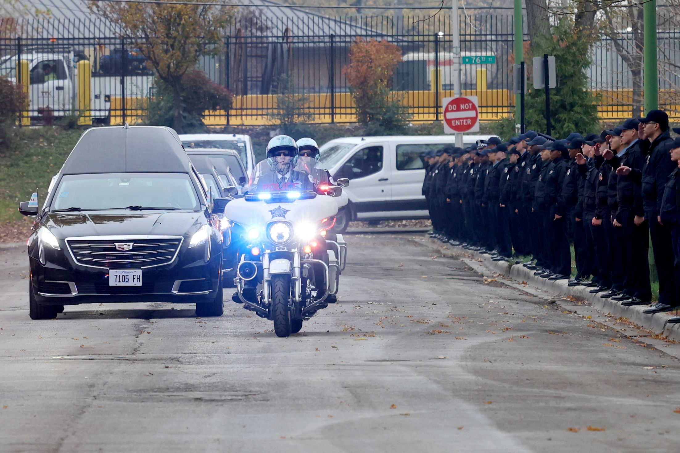 Police recruits salute as the funeral procession comes down Maplewood...