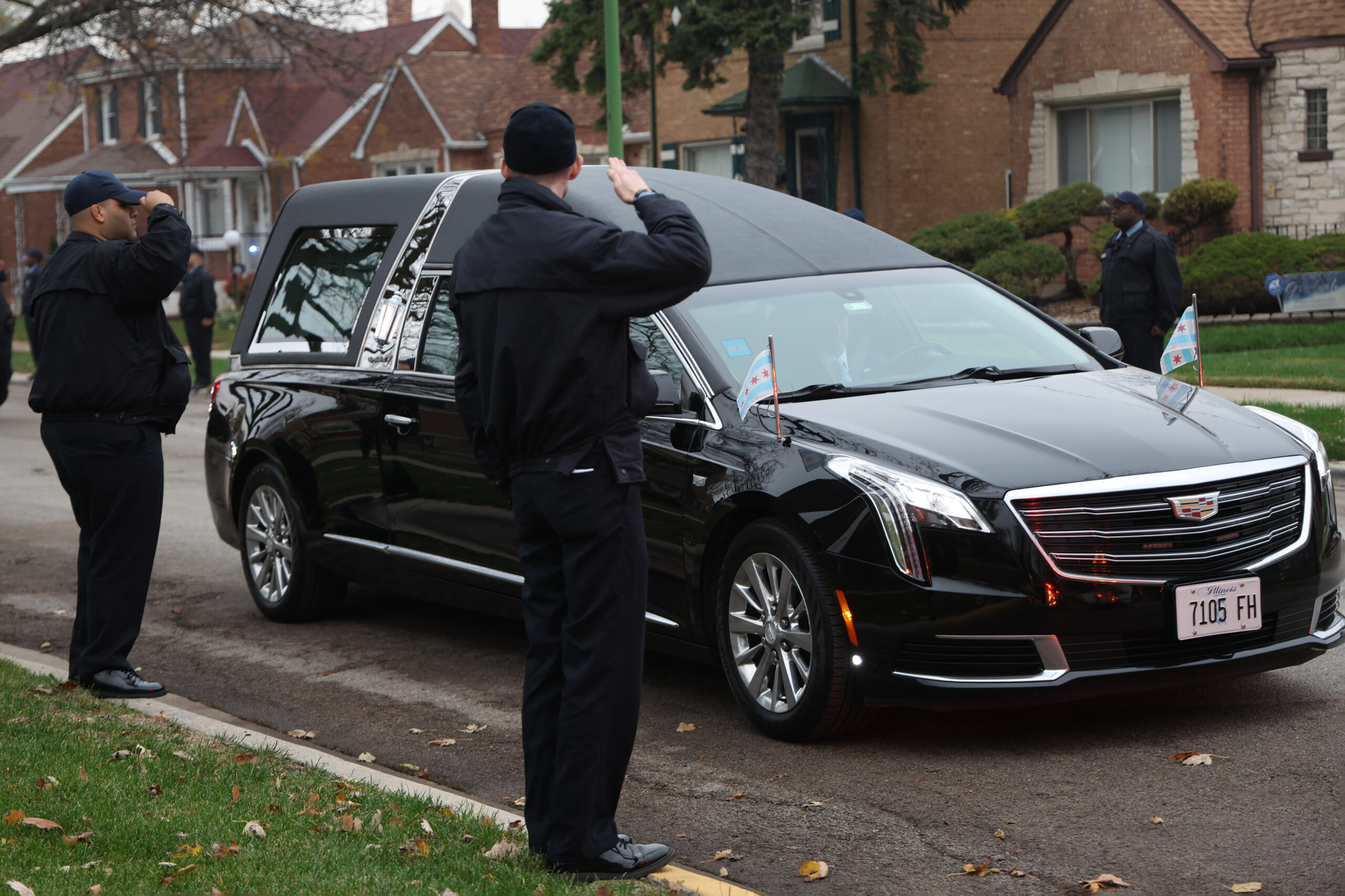 Police recruits salute as the funeral procession comes down Maplewood...