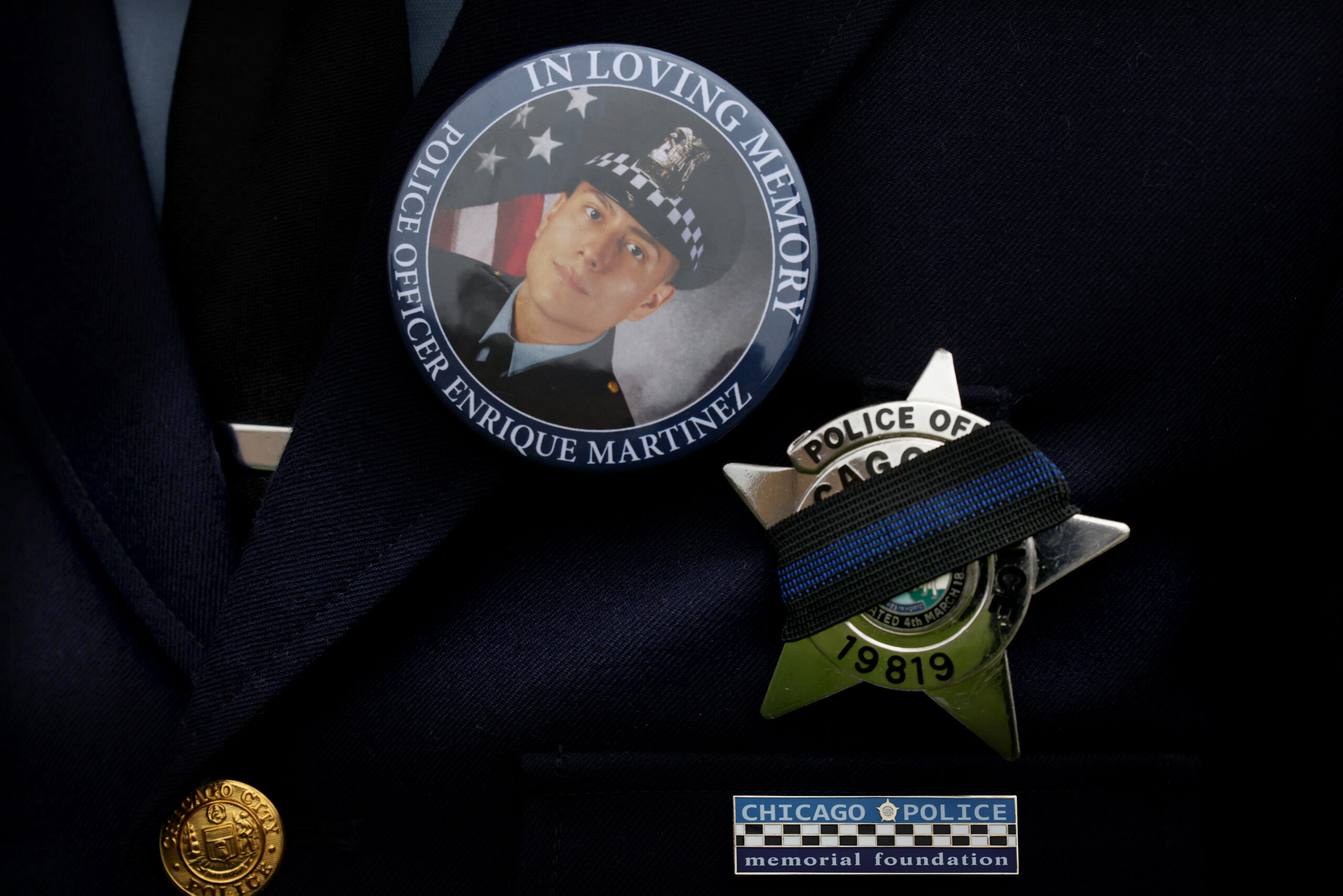 A police officer wears a button with the image of...