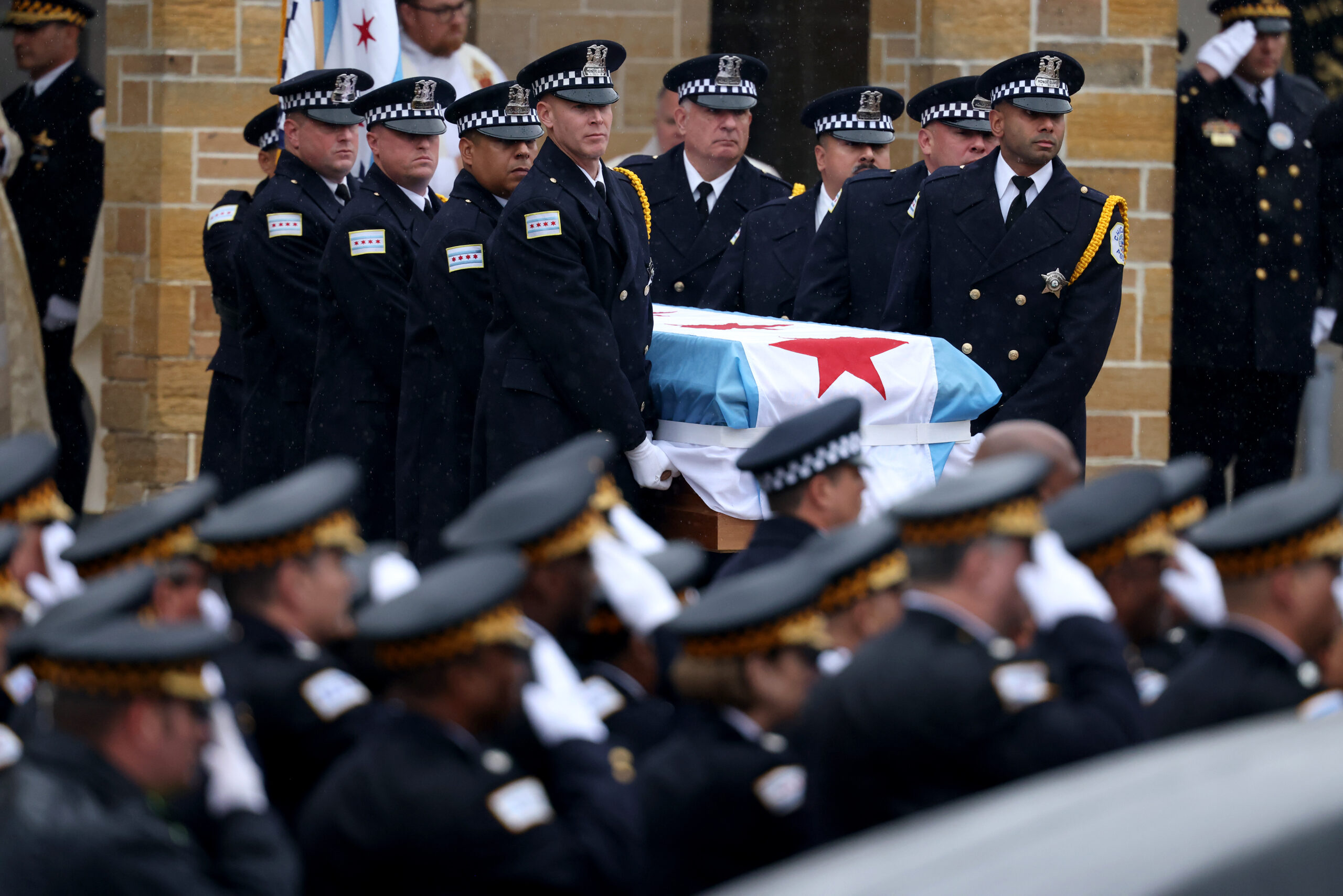 Pallbearers carry the casket out following funeral services for slain...