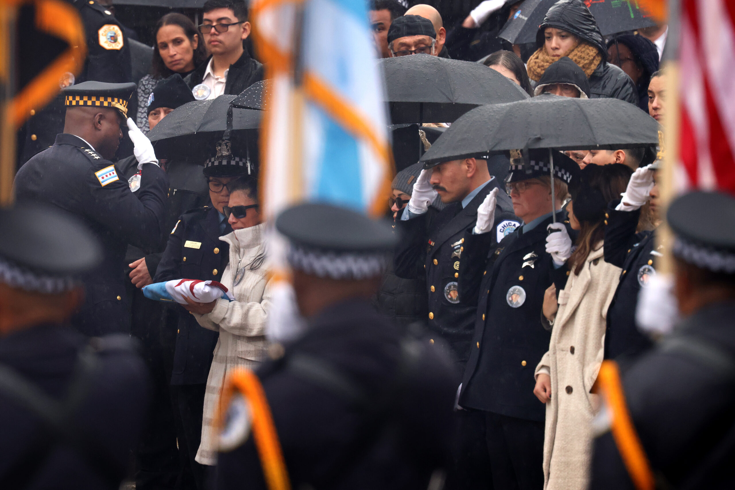 Police Superintendent Larry Snelling presents the flag to the officer’s...