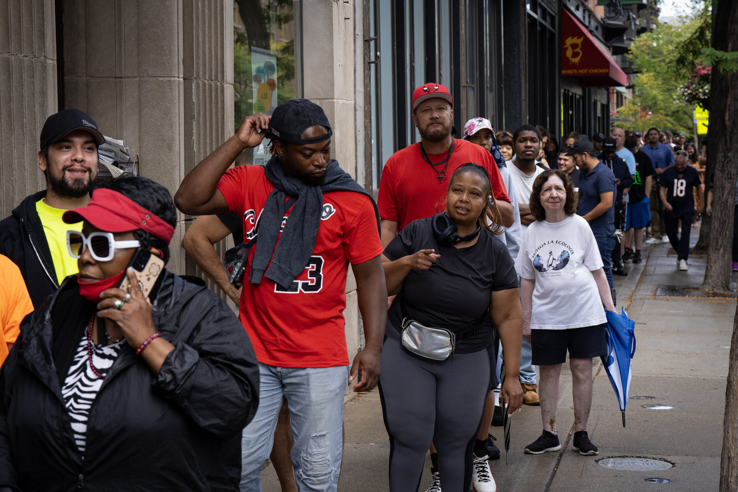 A crowd waits in line for free hot dogs at...