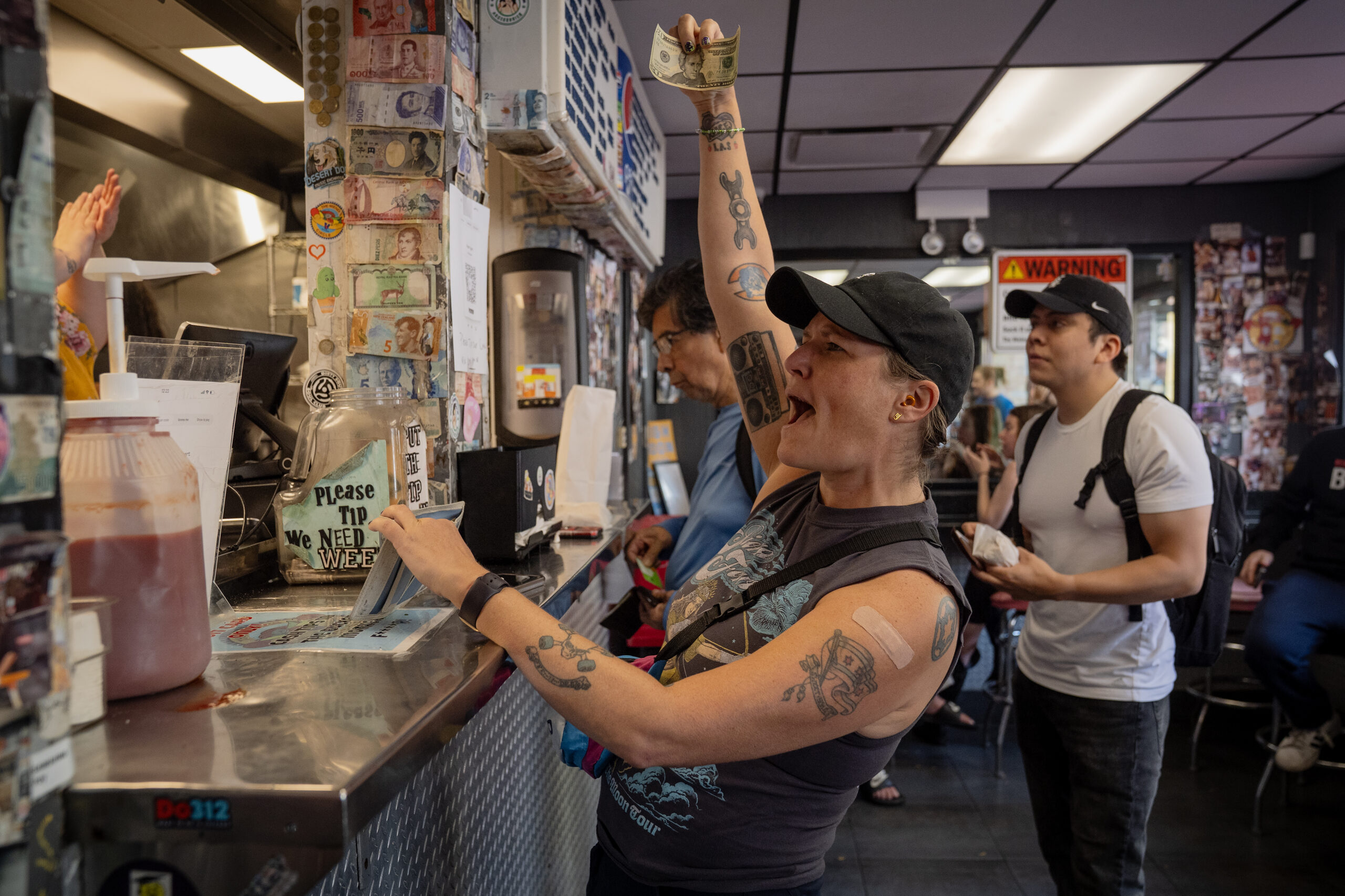 Val Capone tips the staff at The Wieners Circle as...