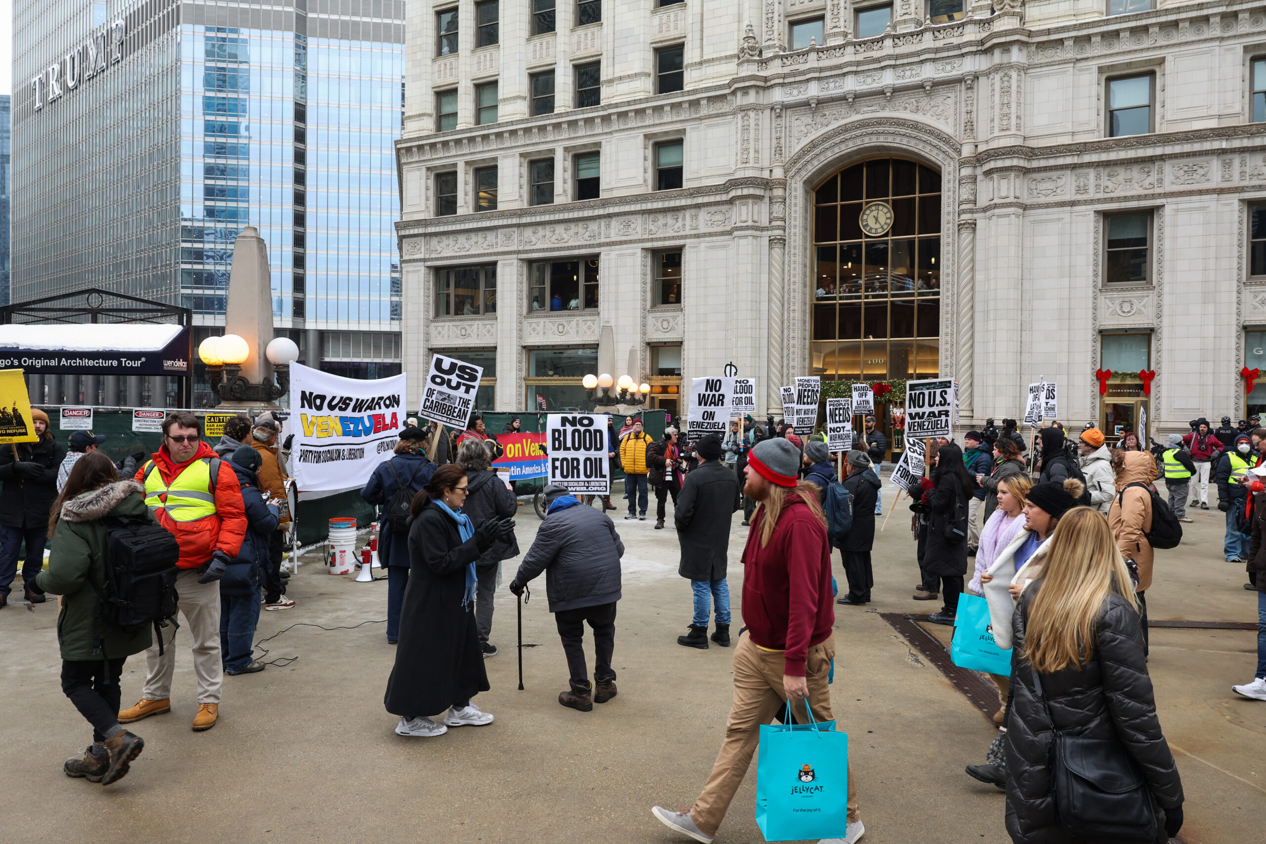 People walk past as demonstrators decry recent U.S. military actions...