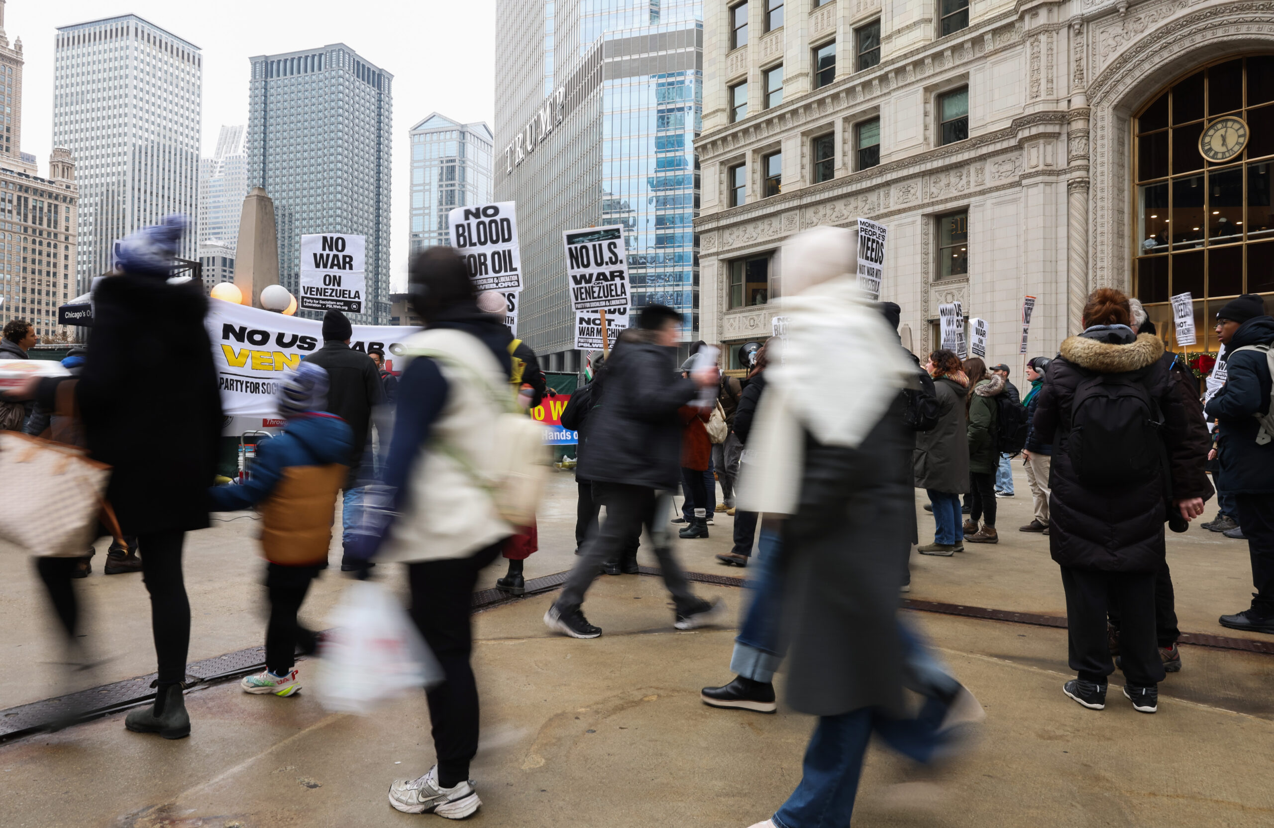 People walk past as demonstrators decry recent U.S. military actions...