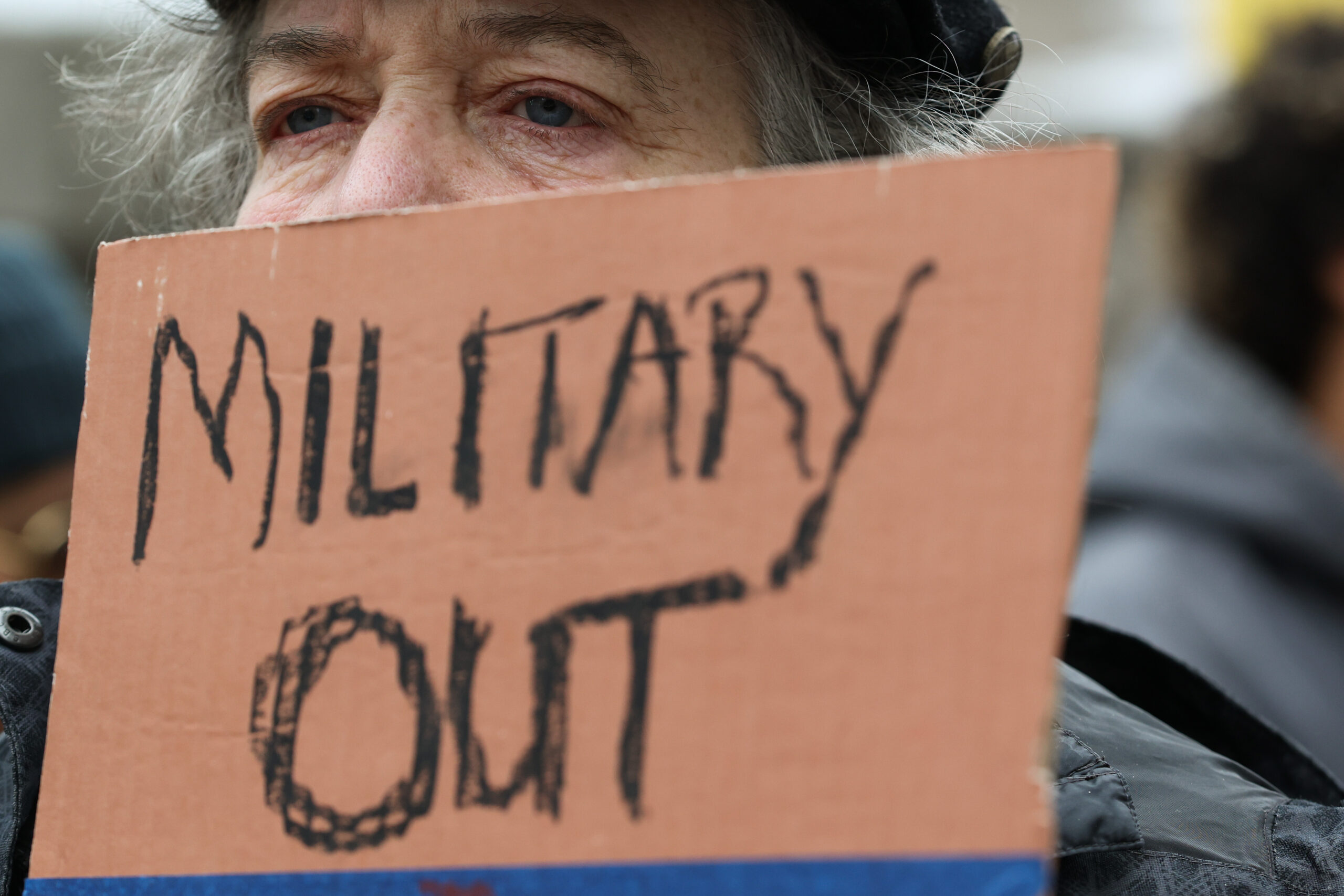 Pat Ruch holds a sign during a demonstration decrying recent...