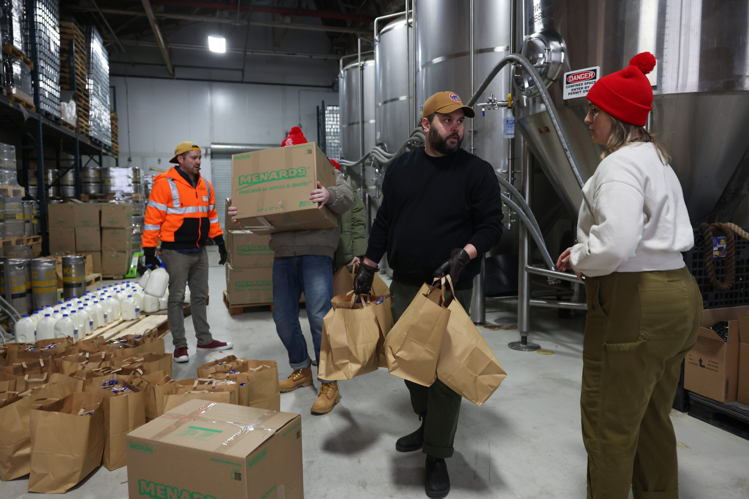 Alex Wojcik, center right, and Carley Quill, right, move groceries...