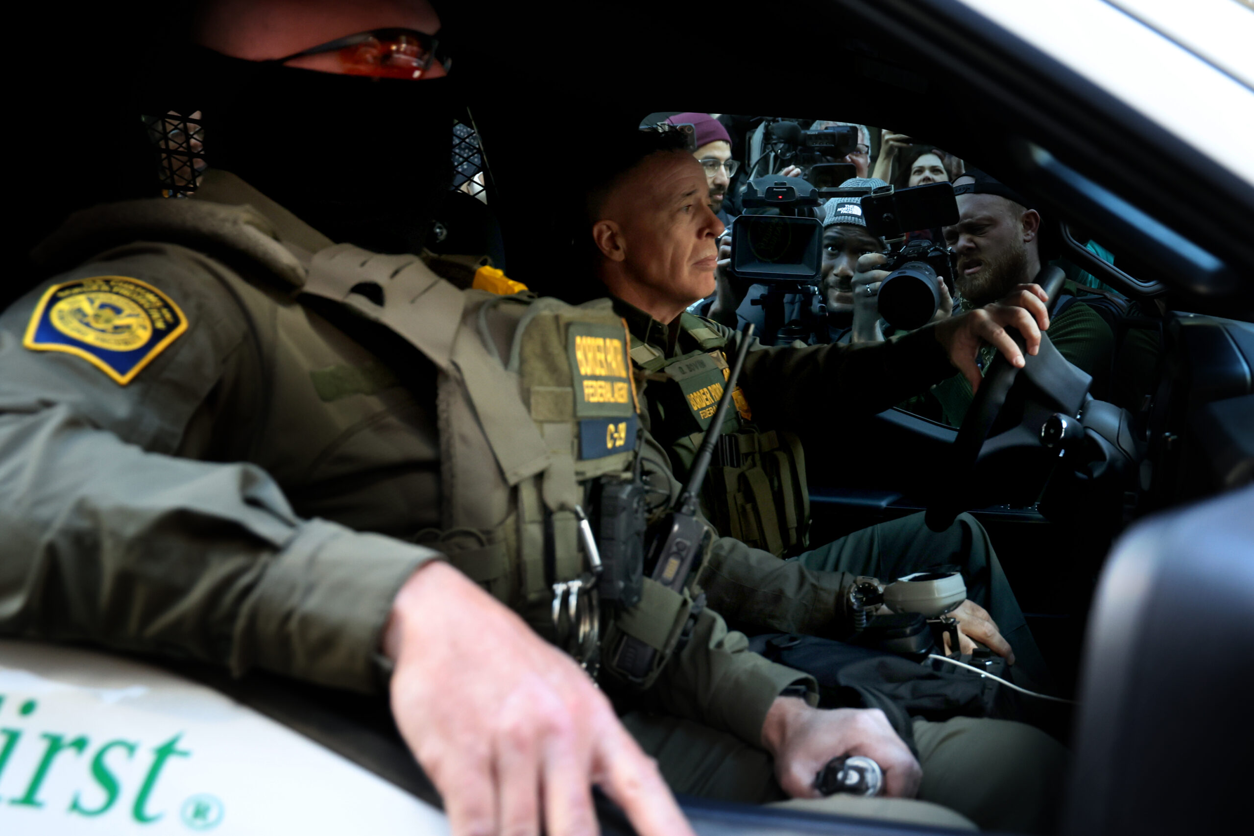 Border Patrol Cmdr. Gregory Bovino, right, prepares to drive away...