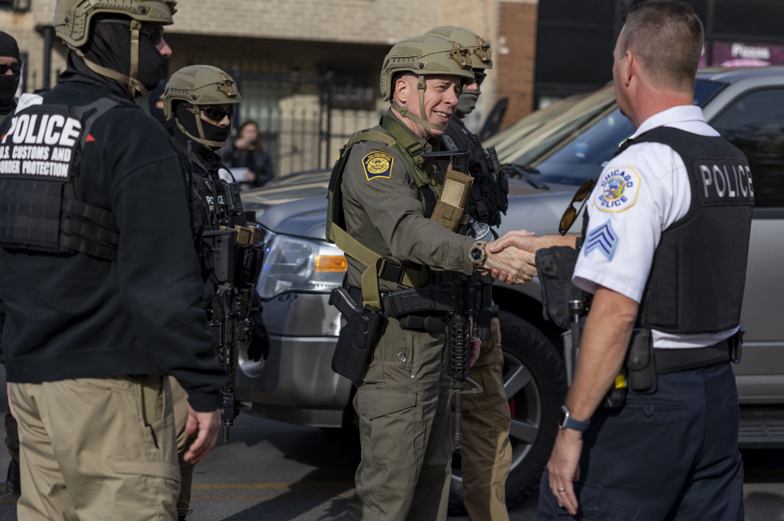Border Patrol Cmdr. Gregory Bovino shakes hands with Chicago police...
